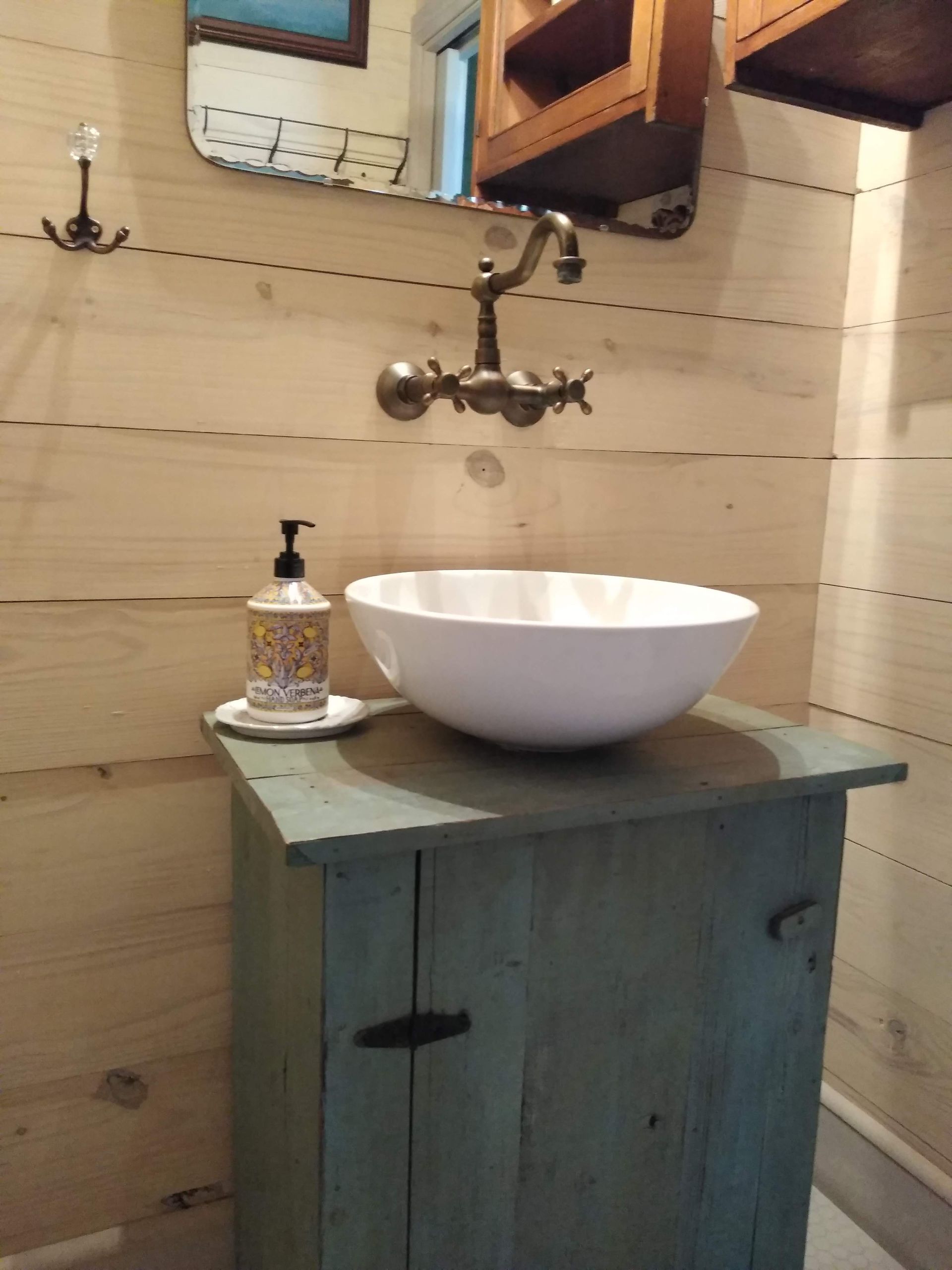 A bathroom with a sink and a soap dispenser