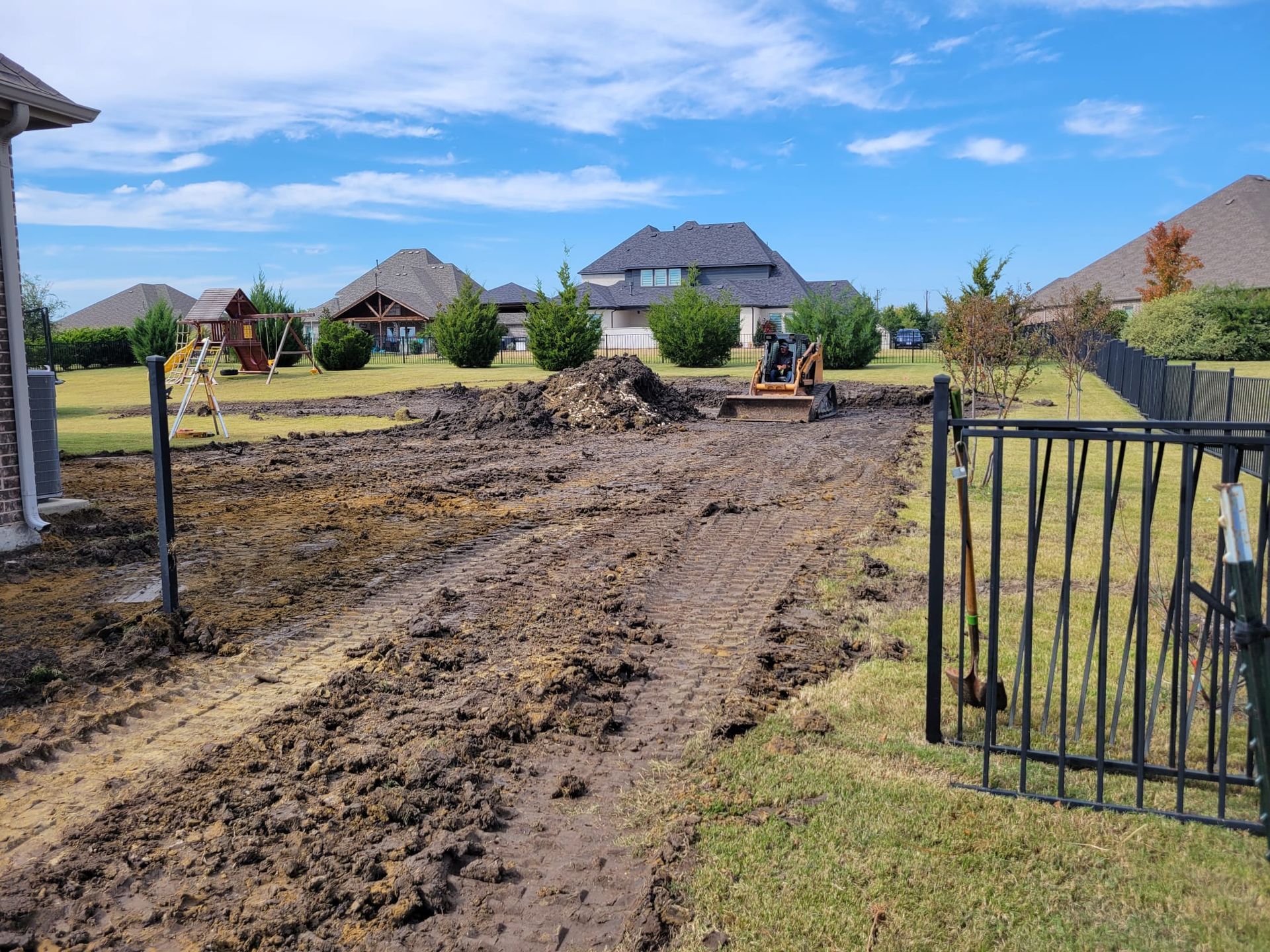 A dirt road leading to a house in a residential area.