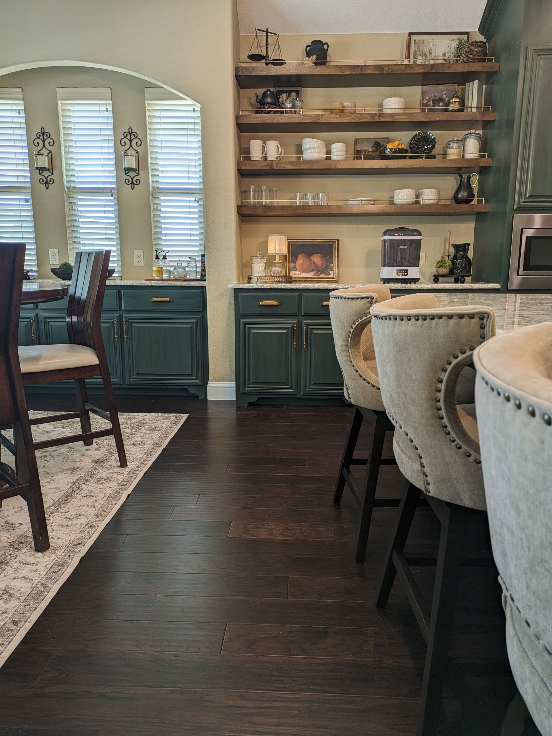 A kitchen with a lot of shelves and chairs in it.