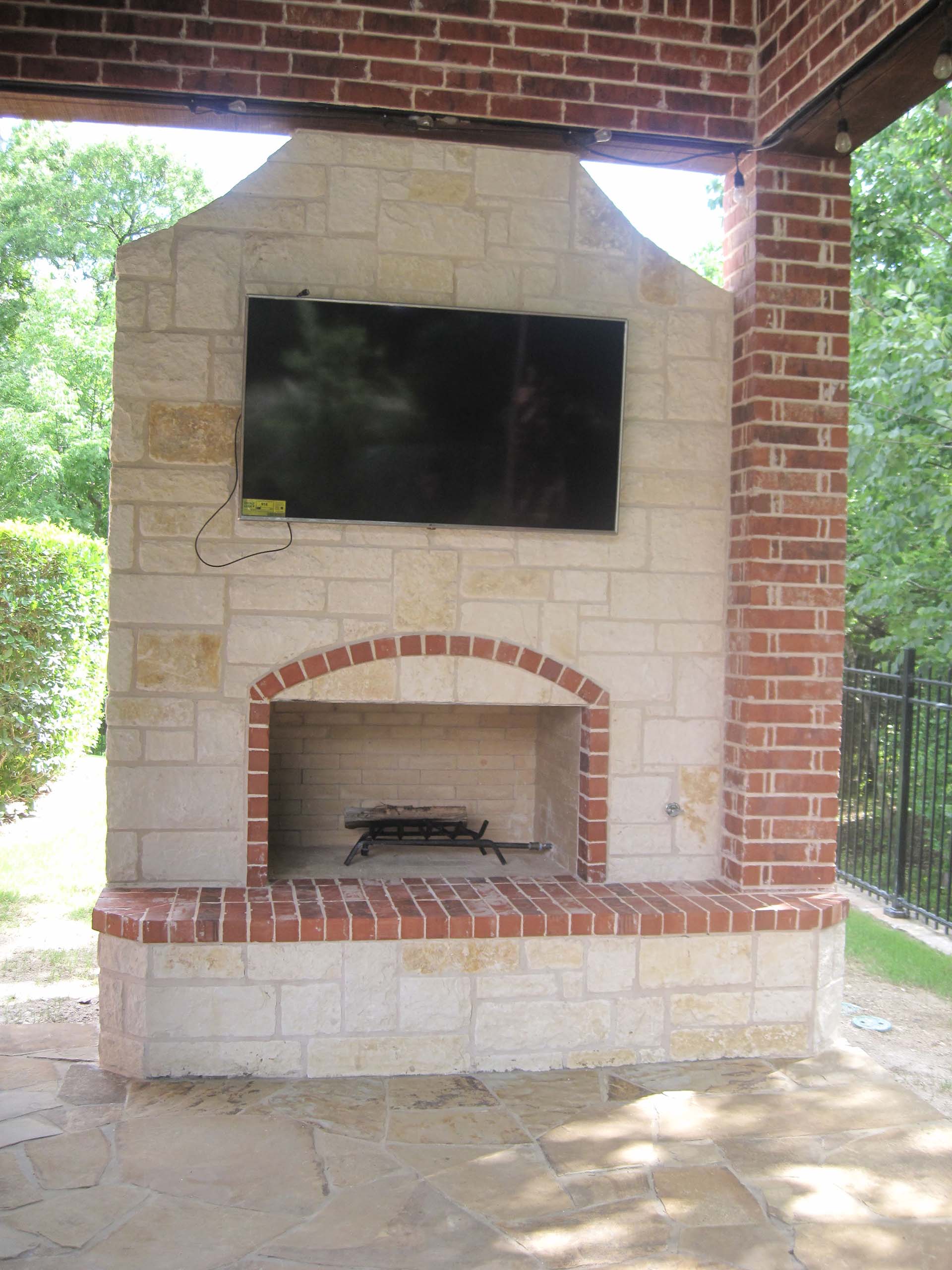 A brick fireplace with a flat screen tv above it