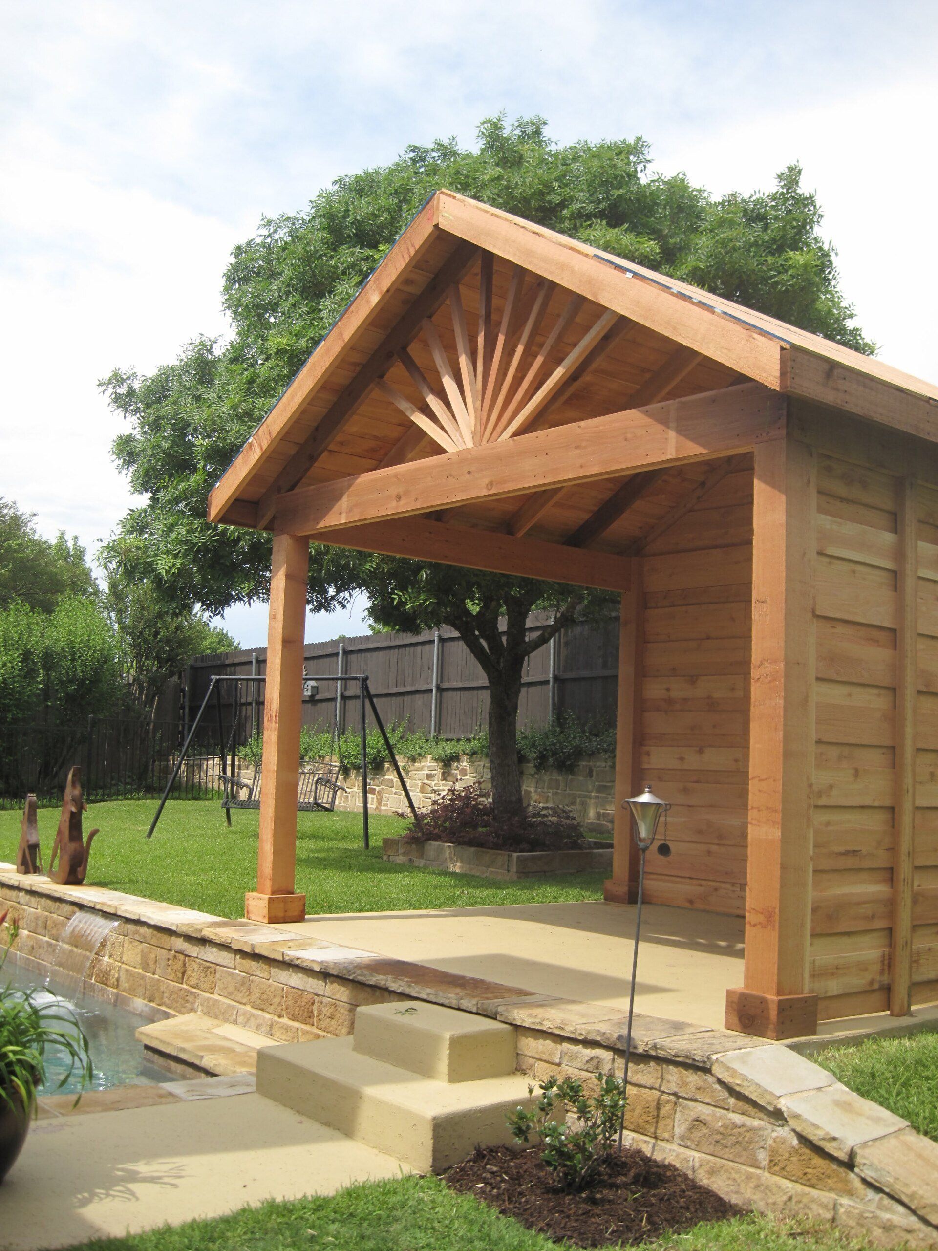 A wooden shed with a roof and stairs leading to it