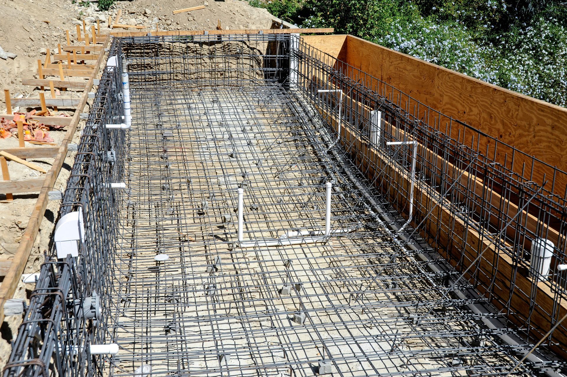 Construction site with steel rebar and concrete foundation formwork in progress