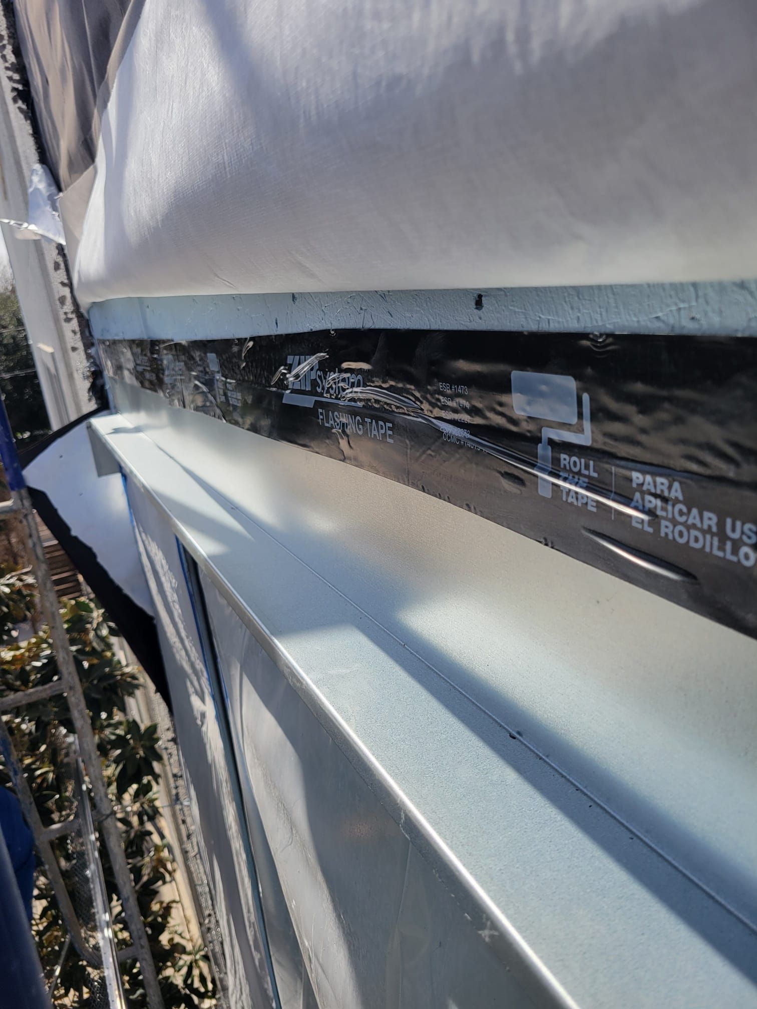 A close up of a building with a roof that is covered in plastic.