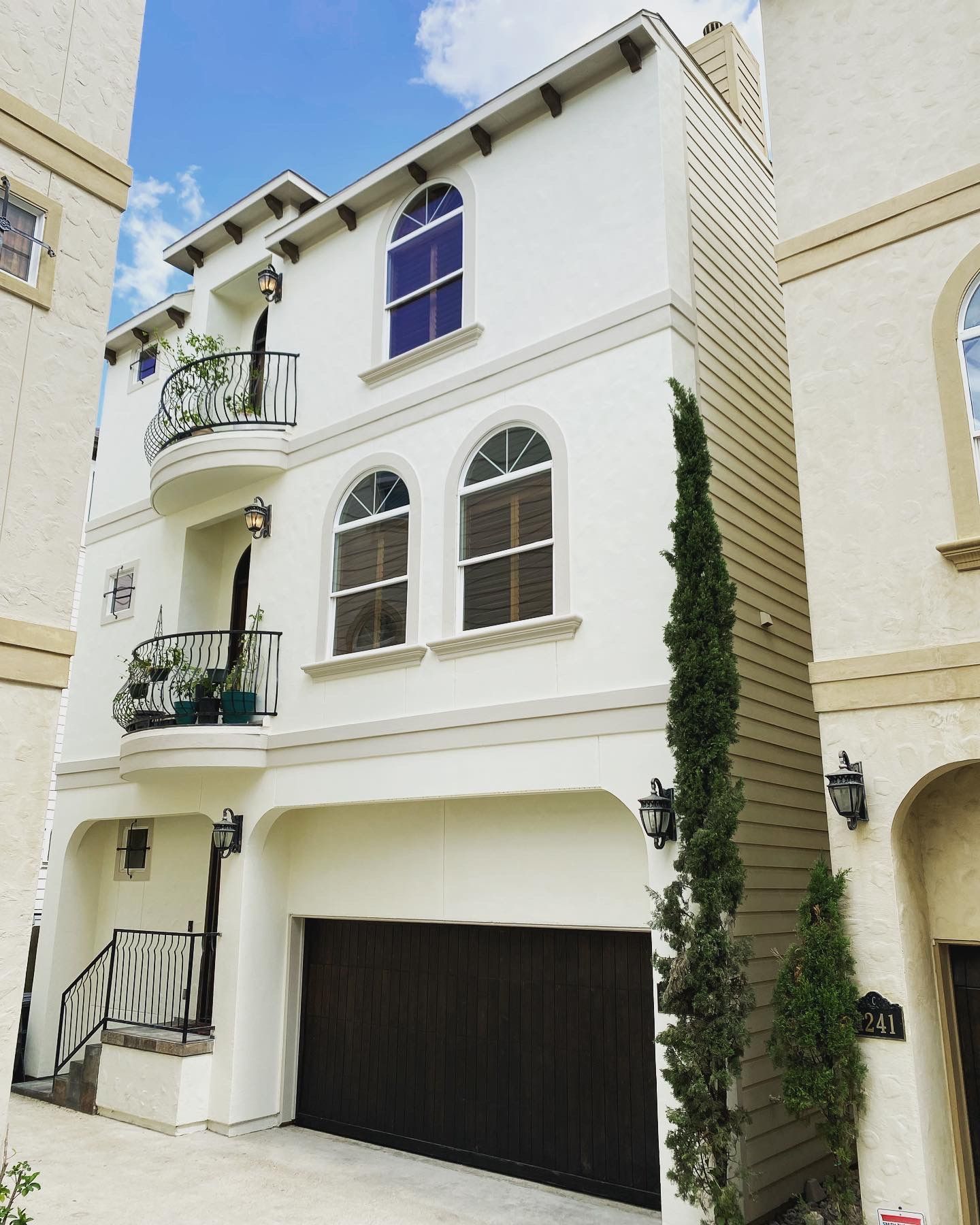 A large white house with a black garage door