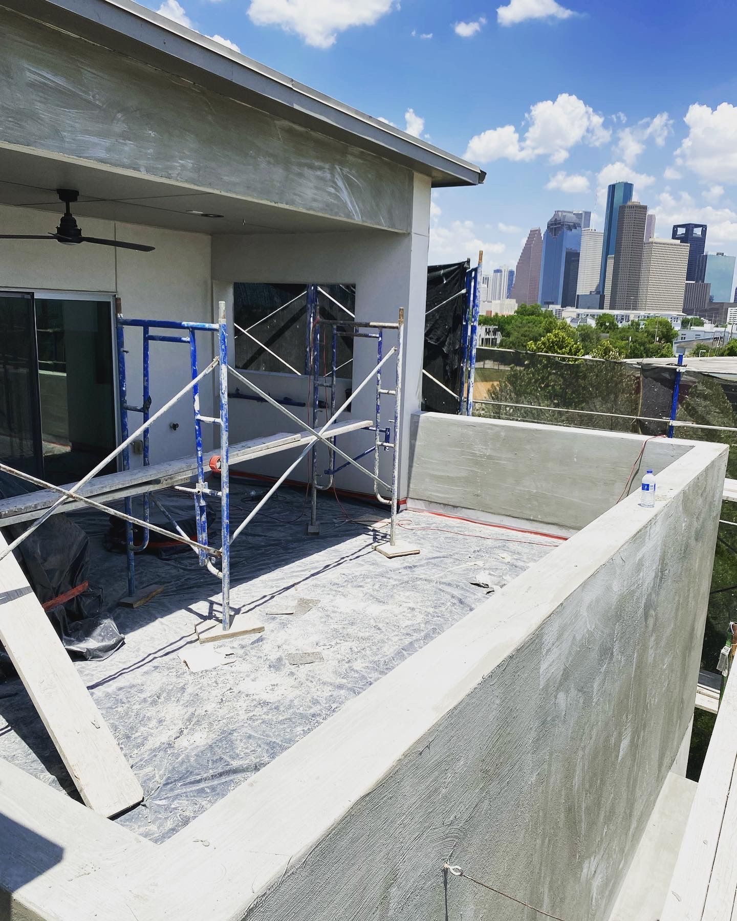 A building under construction with scaffolding and a city in the background