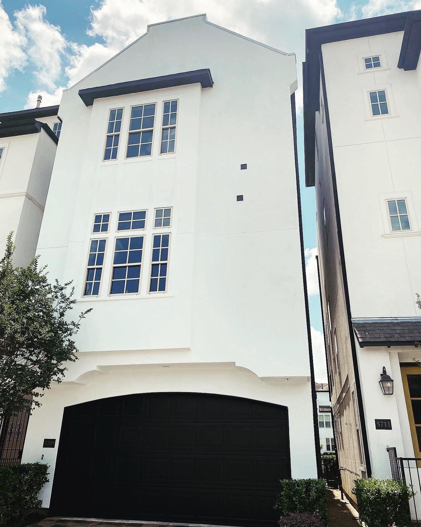 A large white house with a black garage door