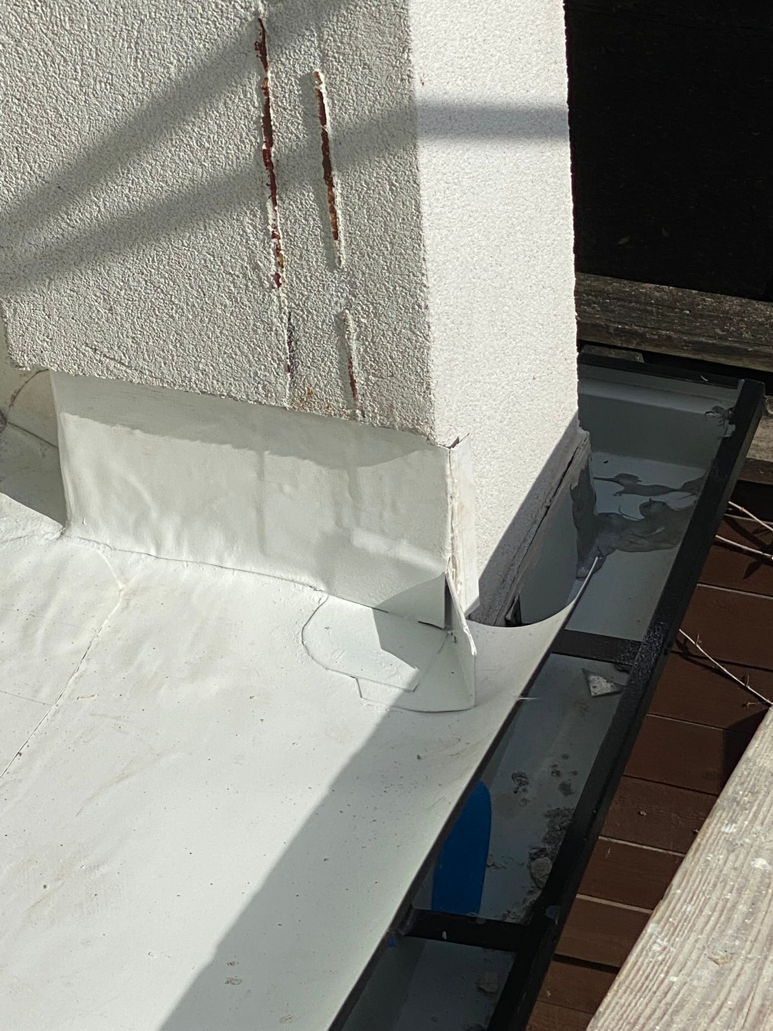 A close up of a white roof with a drain on it.