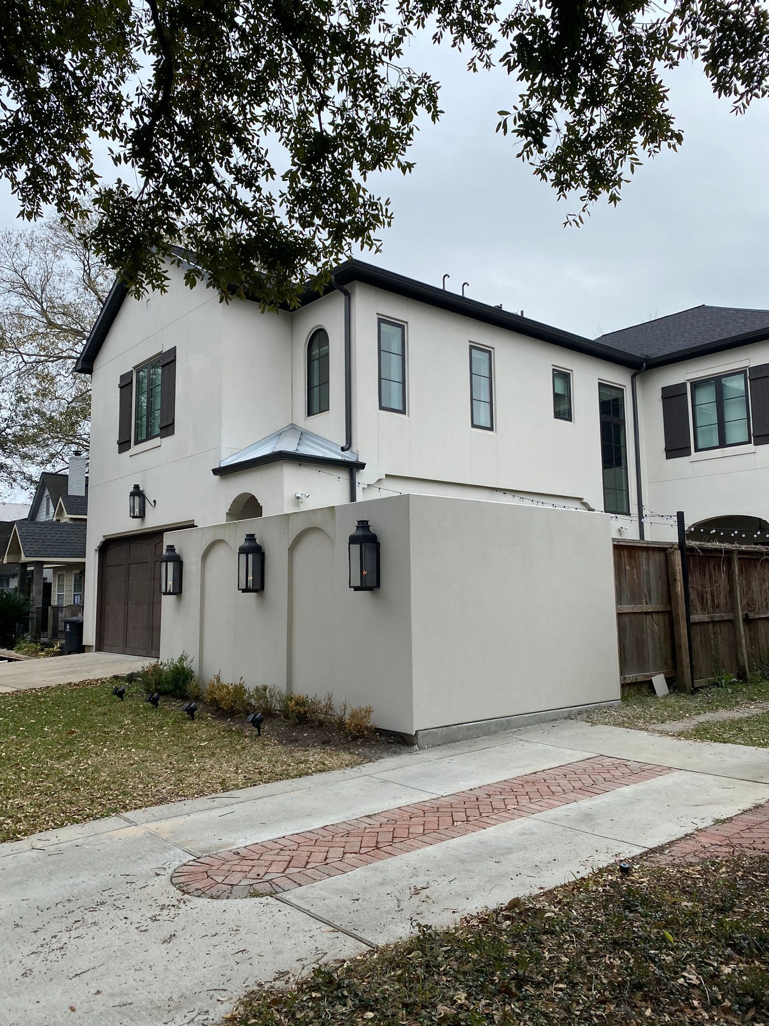 A large white house with a brick driveway in front of it