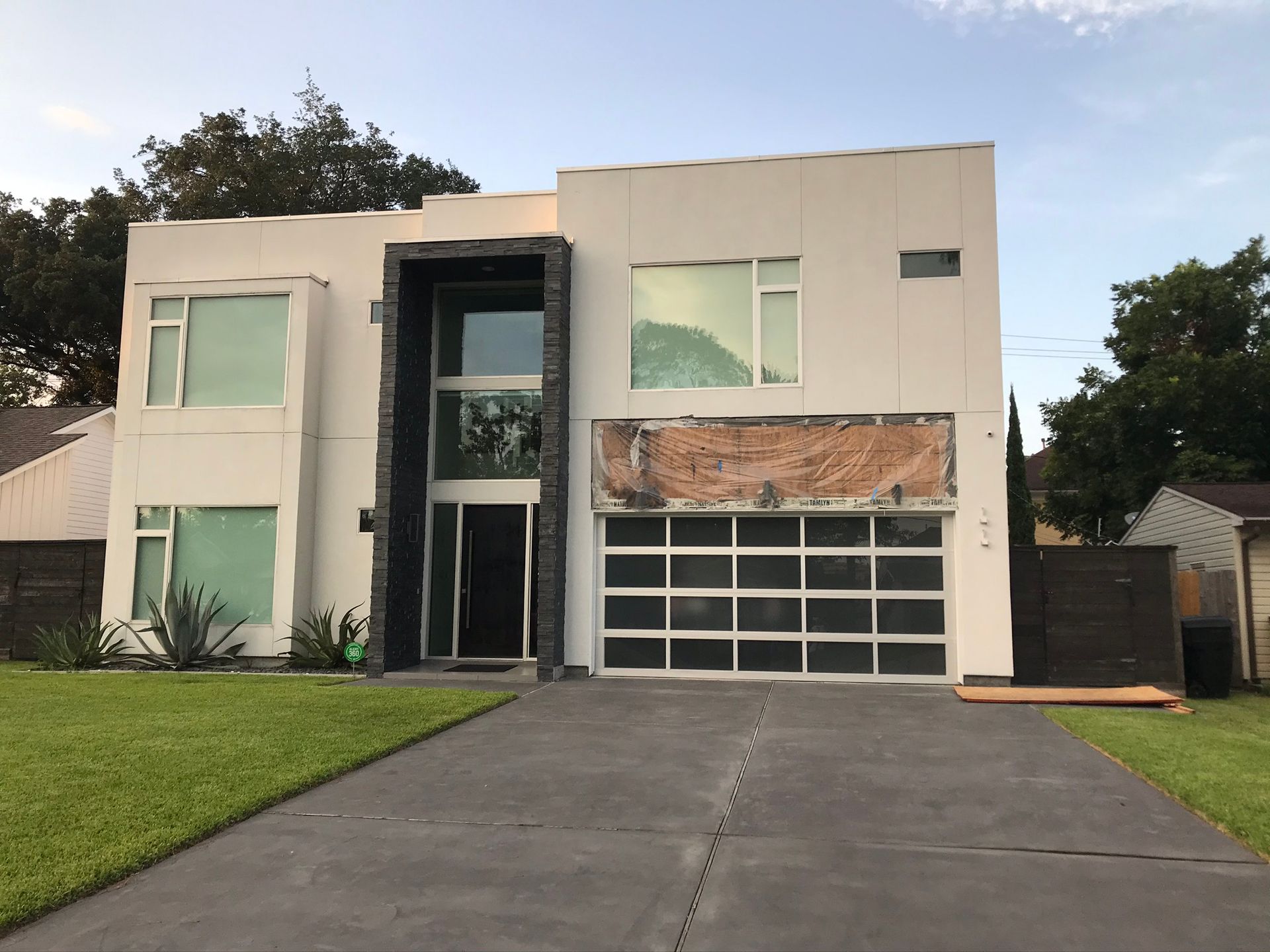 A large white house with a black garage door