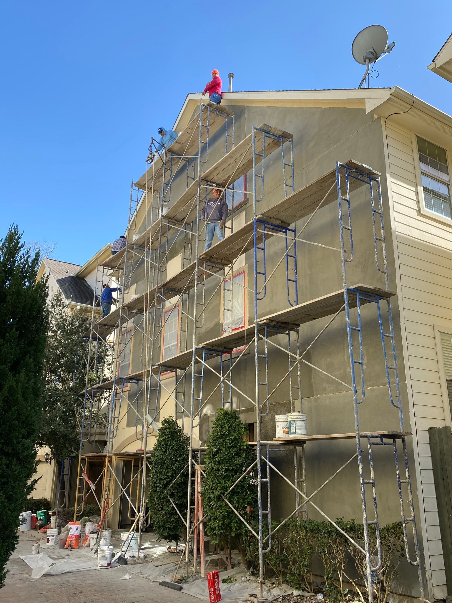 A building is being painted with scaffolding around it.