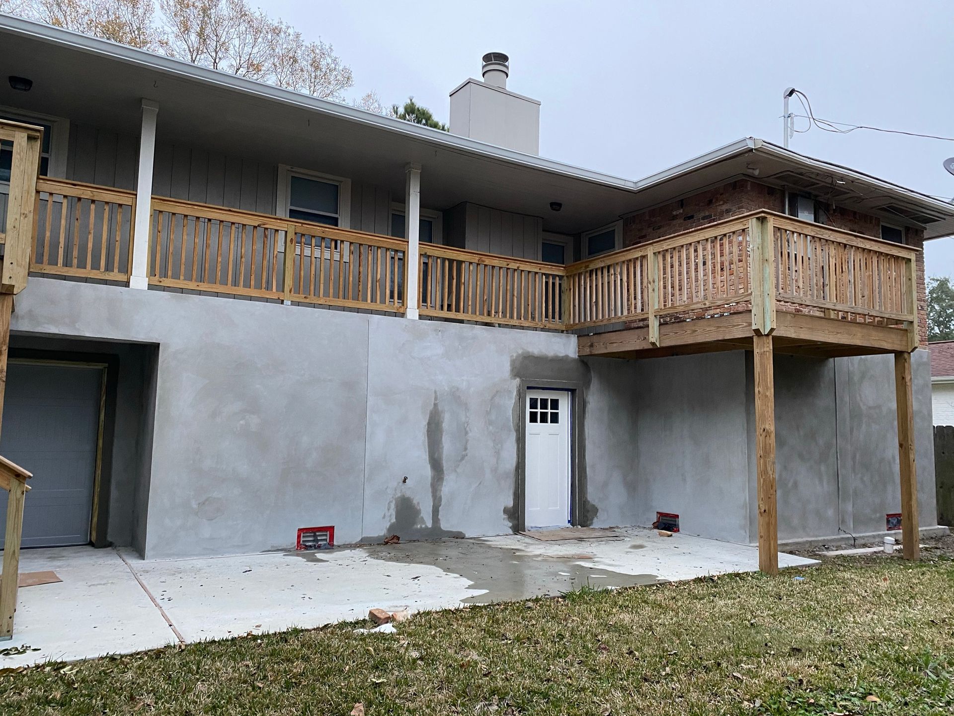 A house with a wooden deck and a concrete foundation