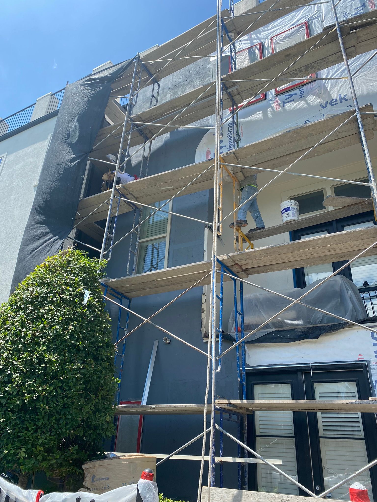 A building is being painted with scaffolding around it.