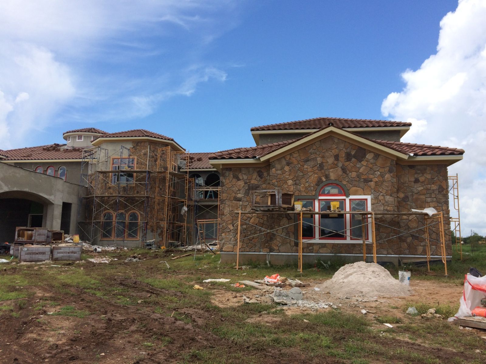 A large house is being built in the middle of a field.