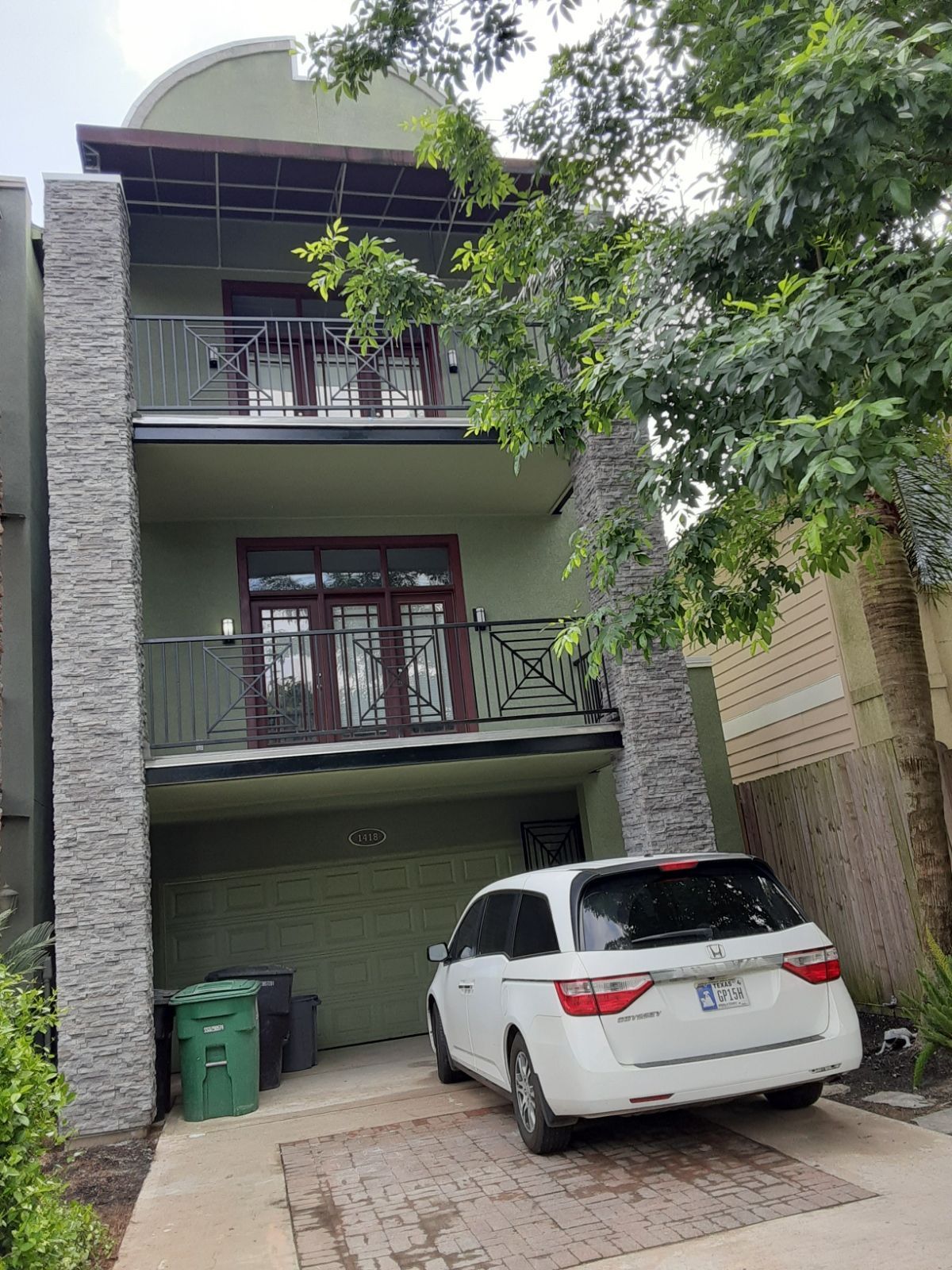 A white car is parked in front of a house.