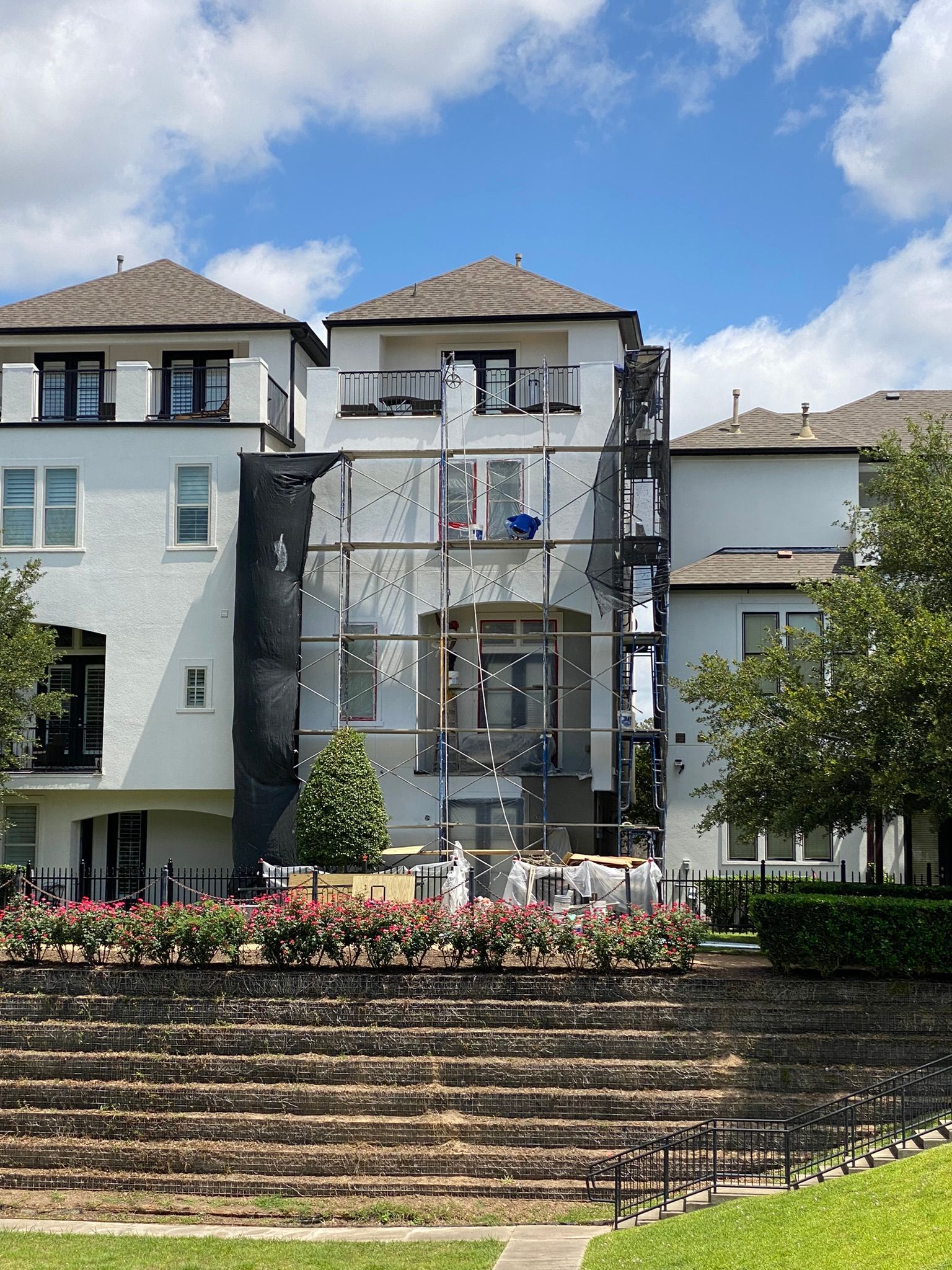 The back of a large white building with stairs leading up to it.
