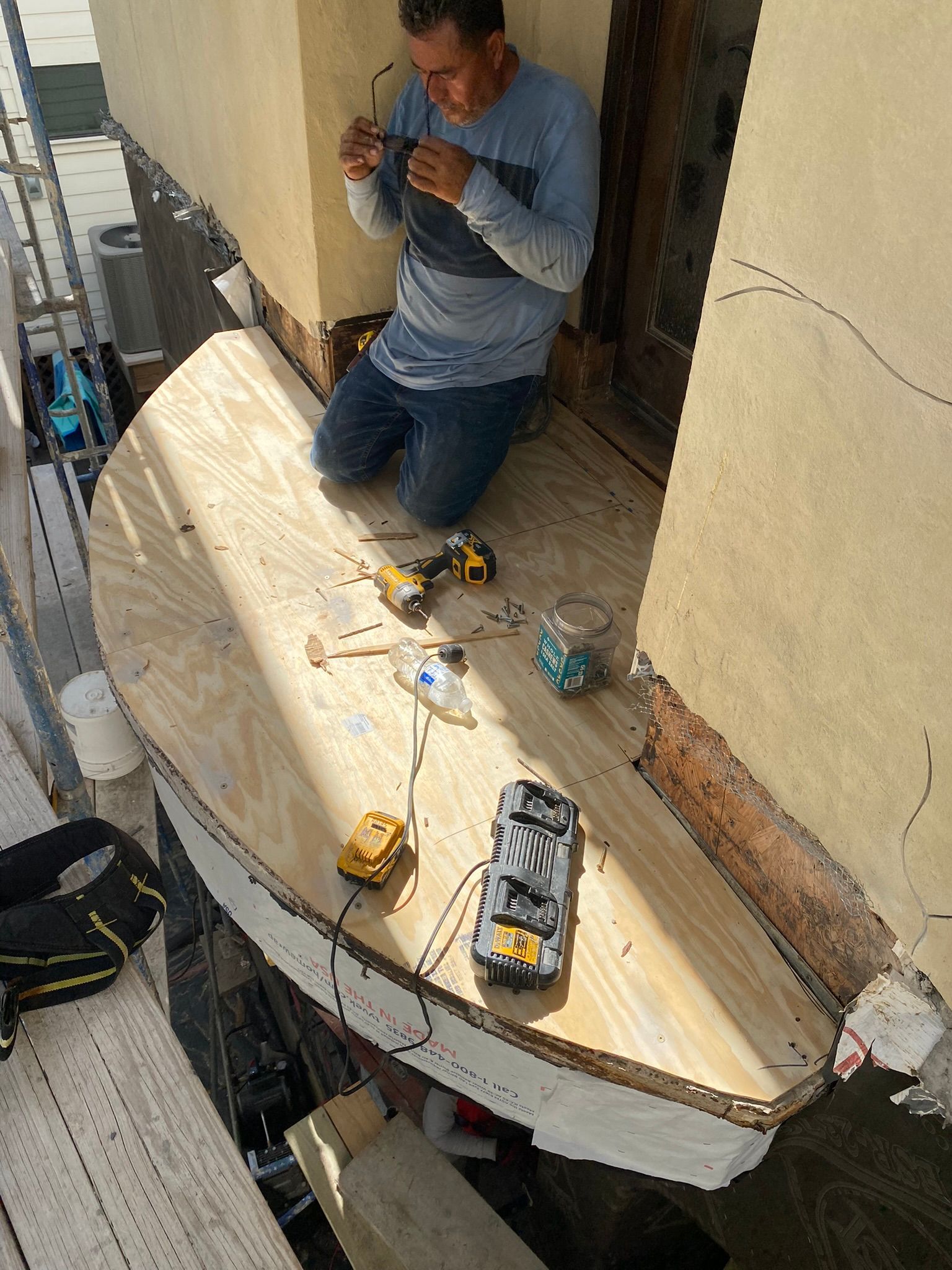 A man is kneeling down on a wooden table.
