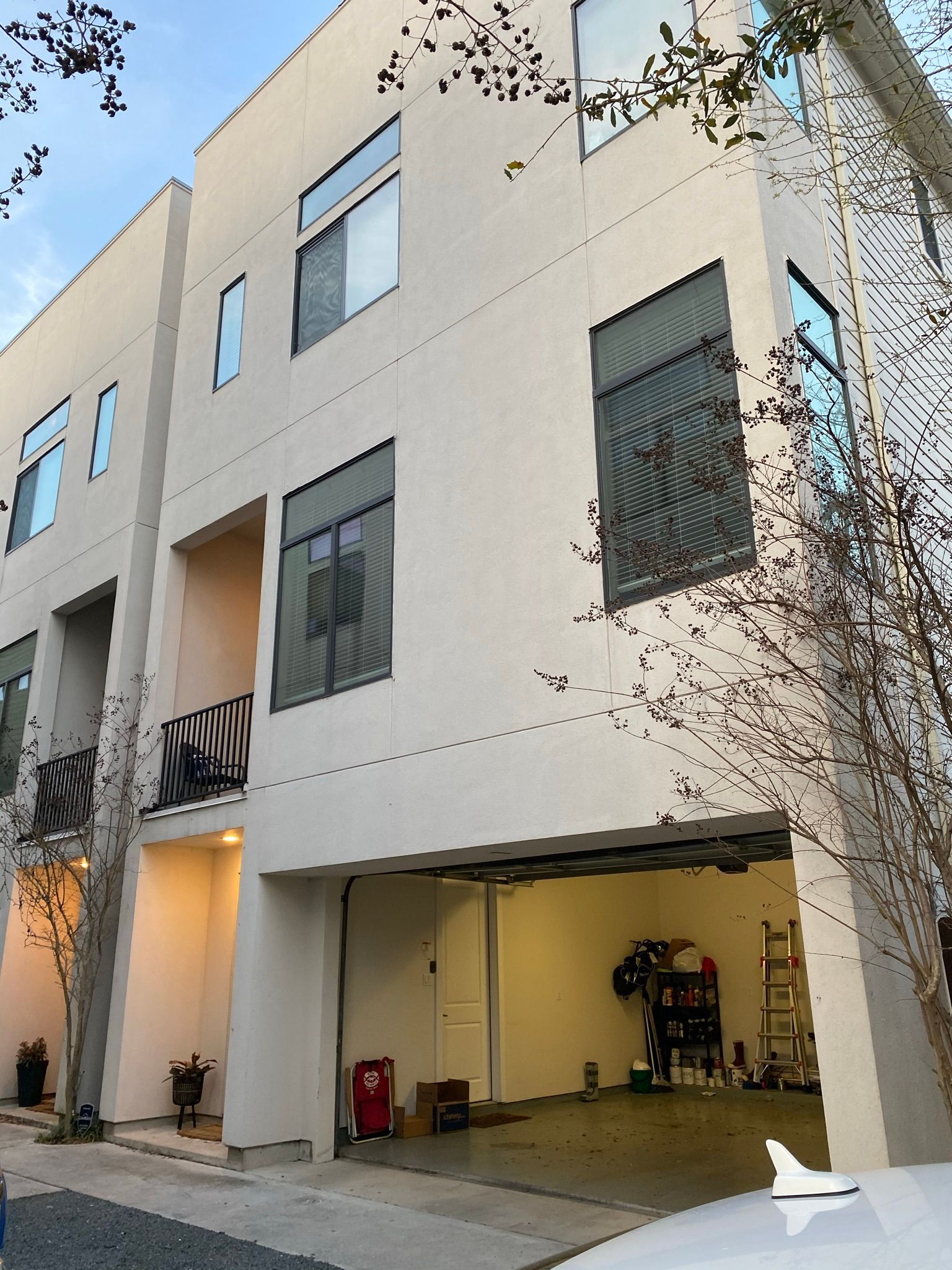 A white building with a car parked in front of it
