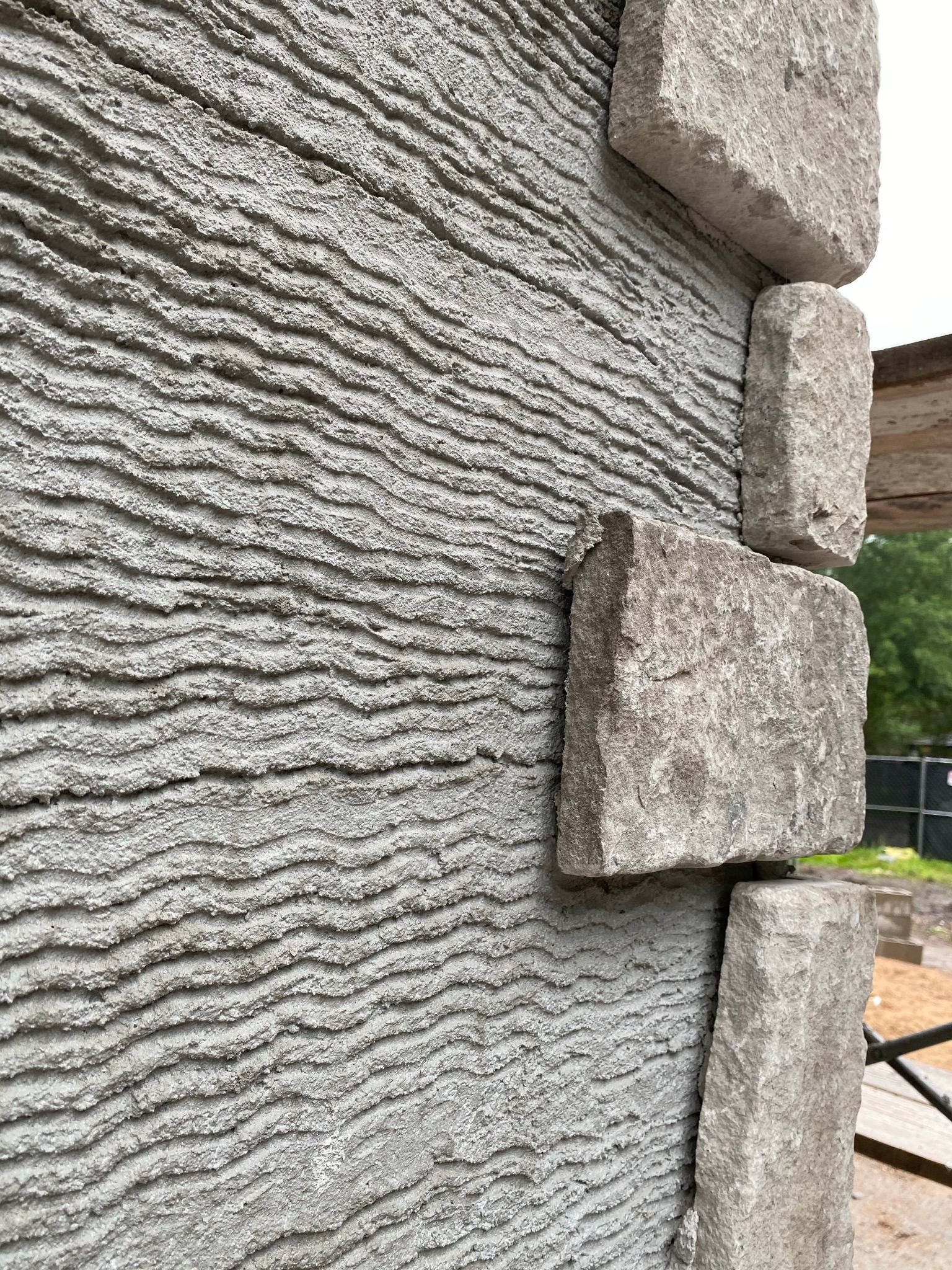 A close up of a stone wall with a brick corner.