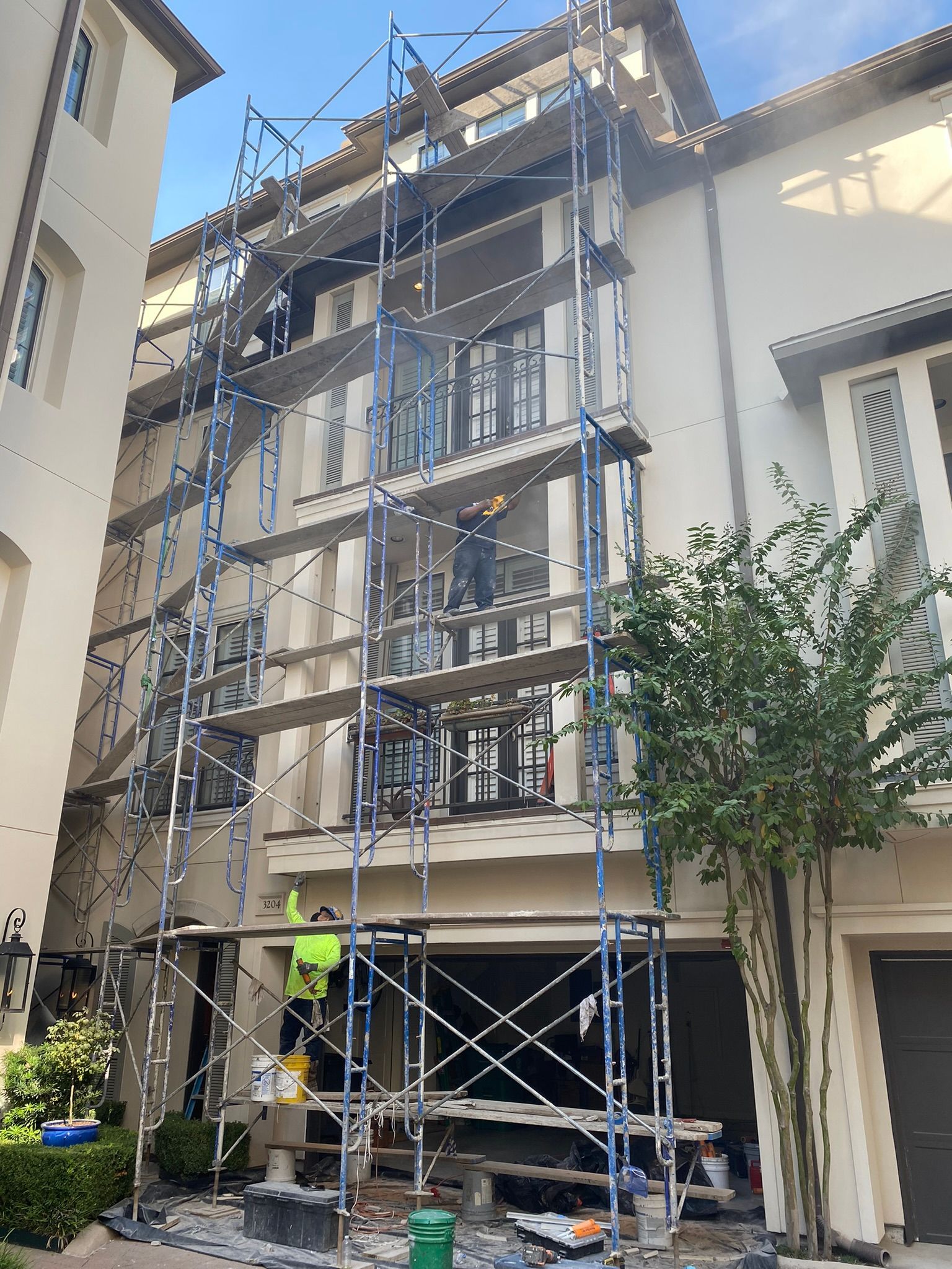 A building is being painted with scaffolding in front of it.