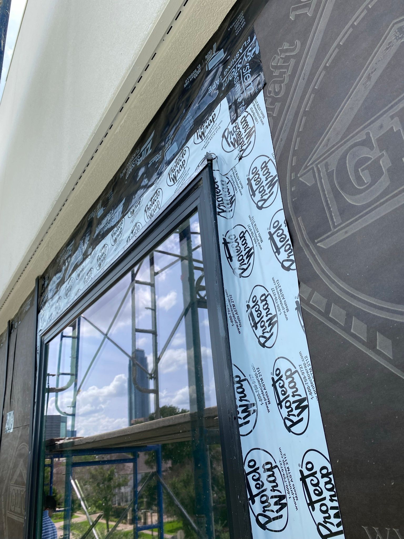 A large window is being installed on the side of a building.