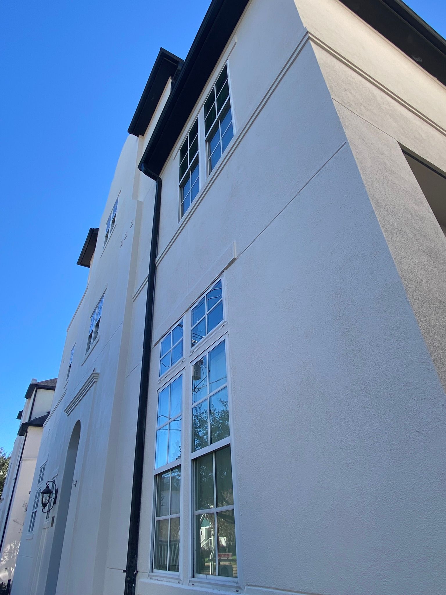 A white building with a lot of windows against a blue sky.