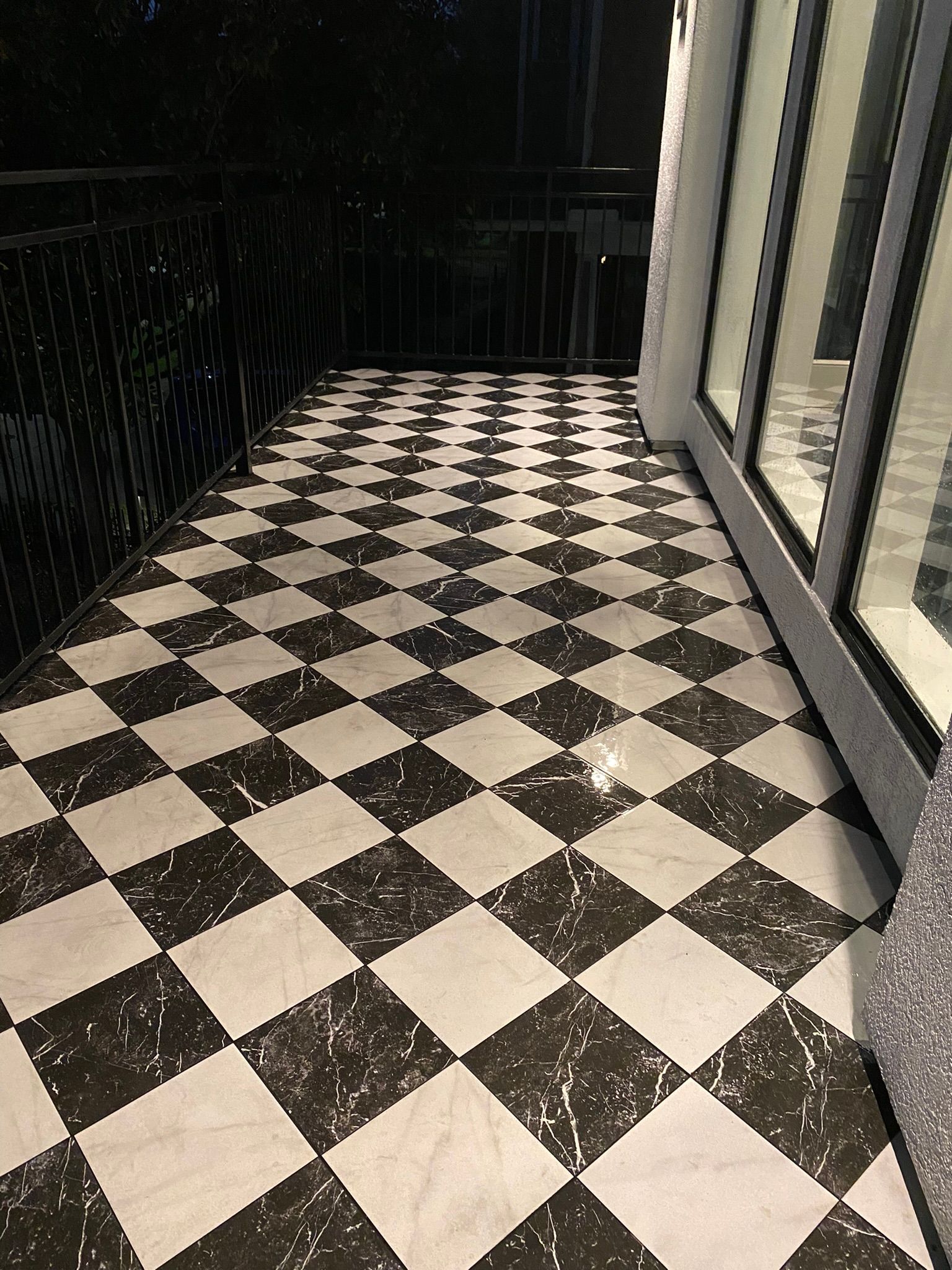 A black and white checkered tile floor on a balcony.