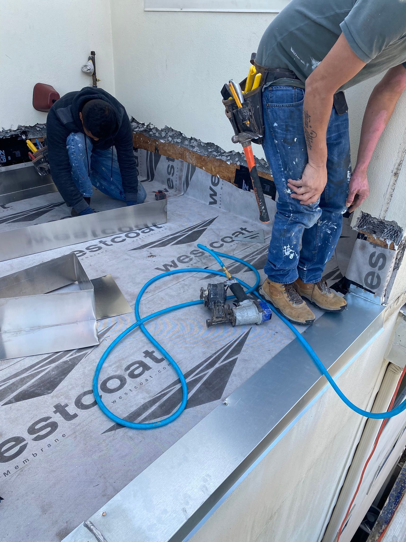 A couple of men are working on a roof.