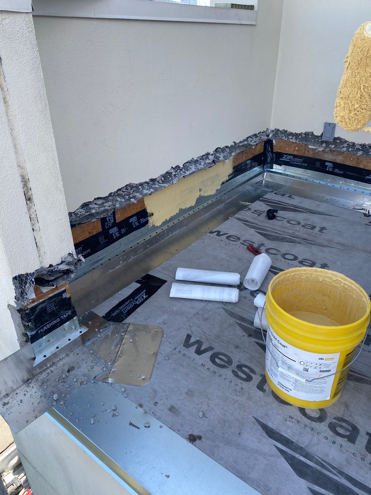 A yellow bucket is sitting on the floor of a building.
