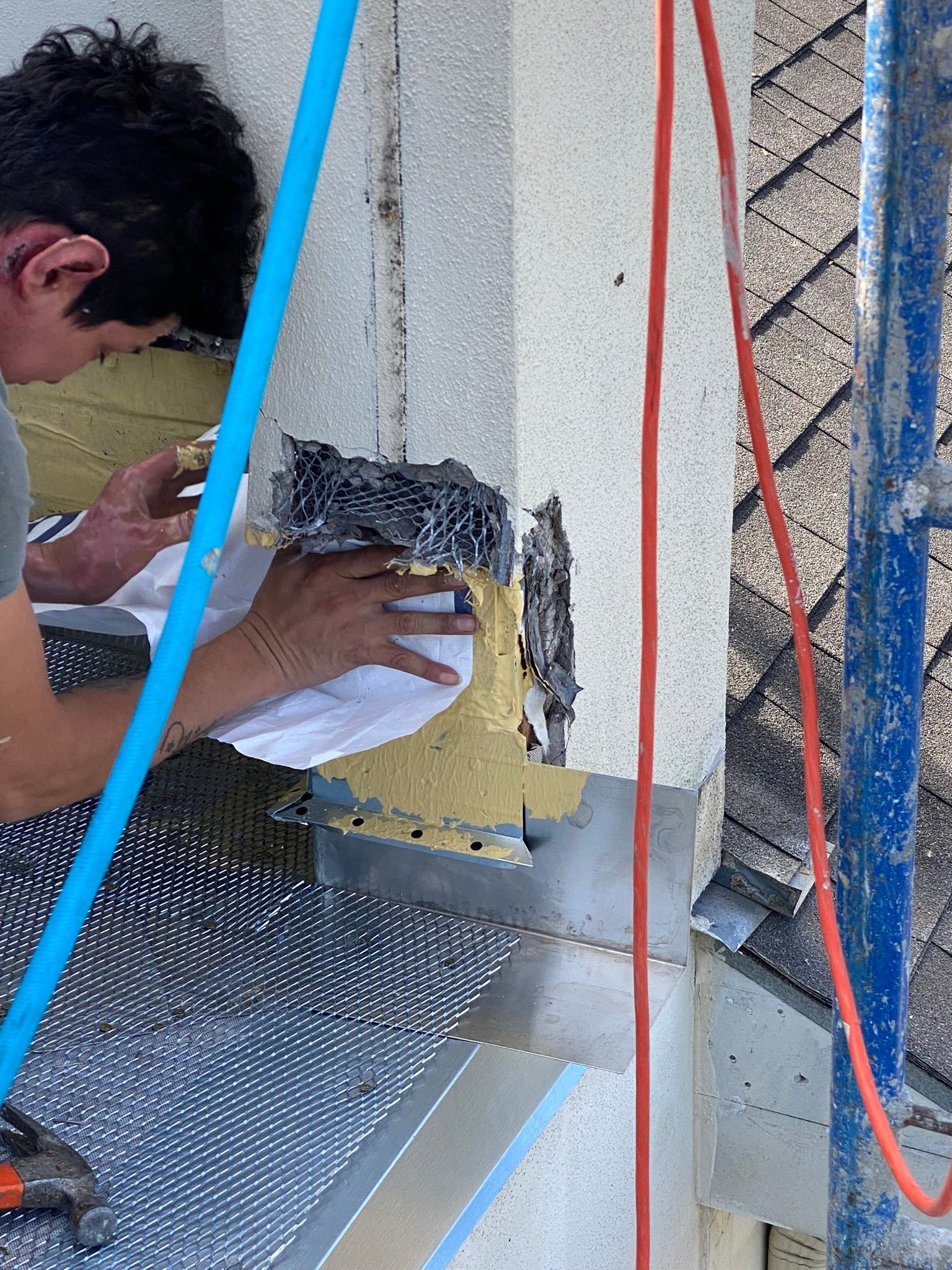 A man is working on a building on a scaffolding.