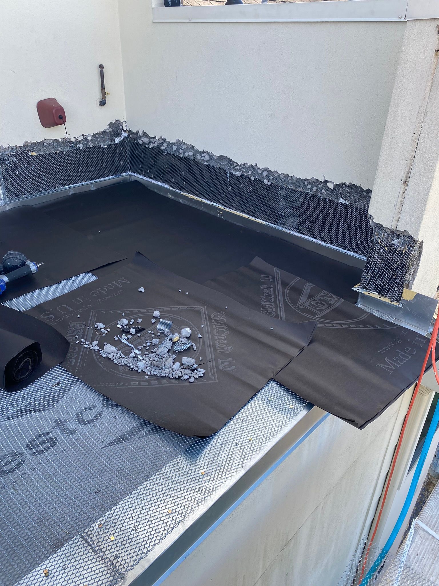A black roof is being installed on a balcony.