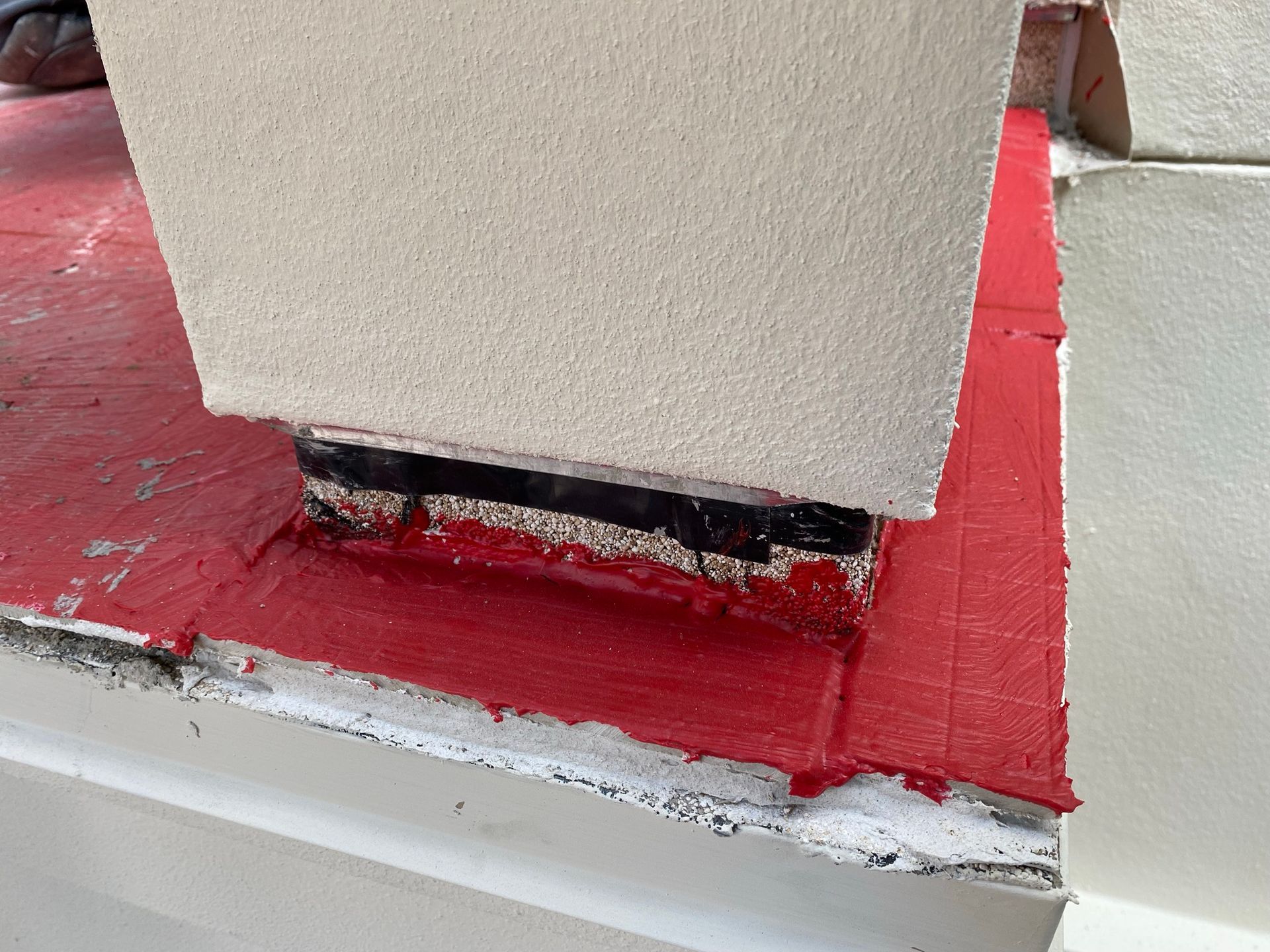 A white wall with a red border is being painted.