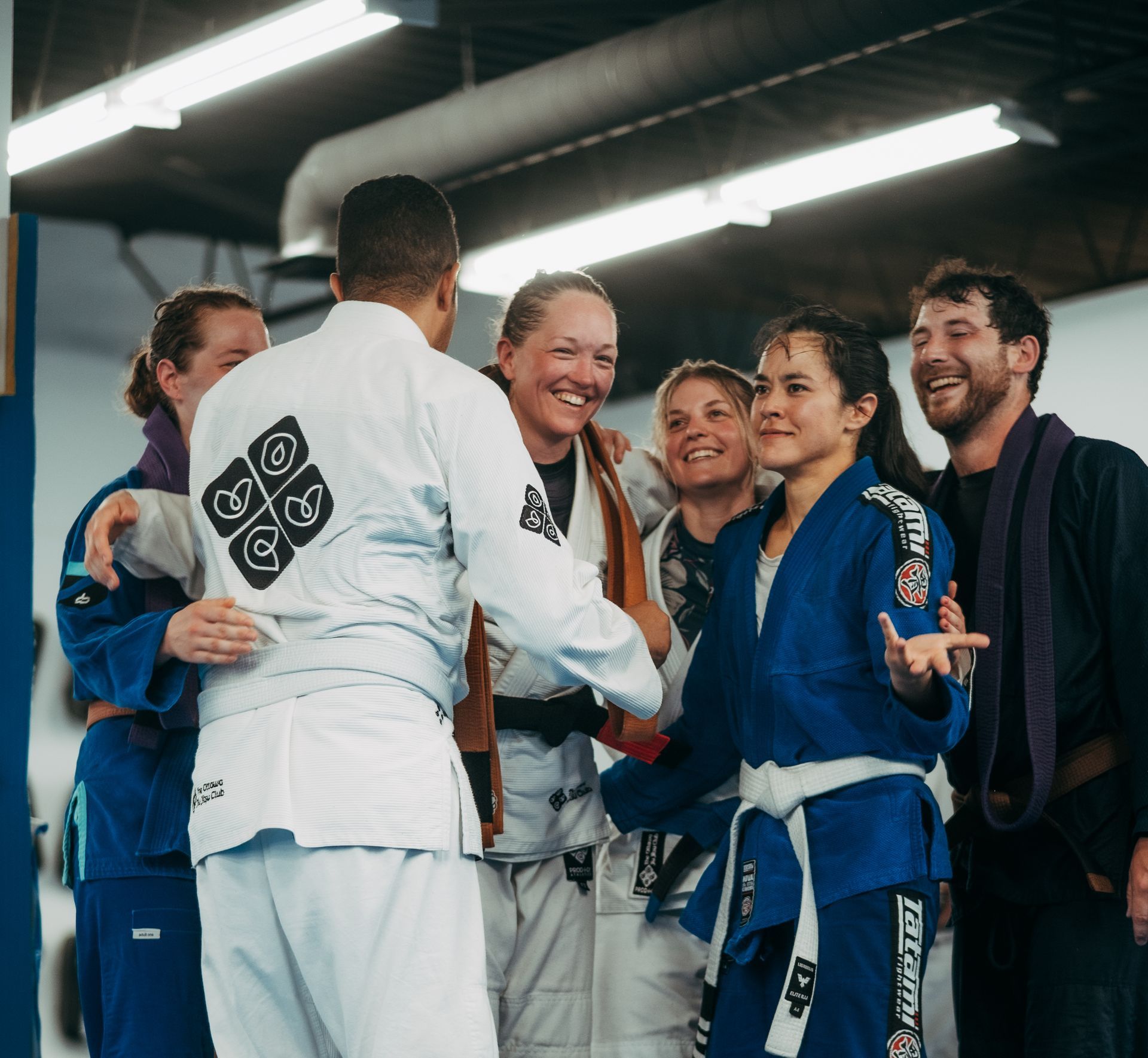 Group of martial artists in gis smiling and shaking hands in the best martial arts center in Ottawa, ON