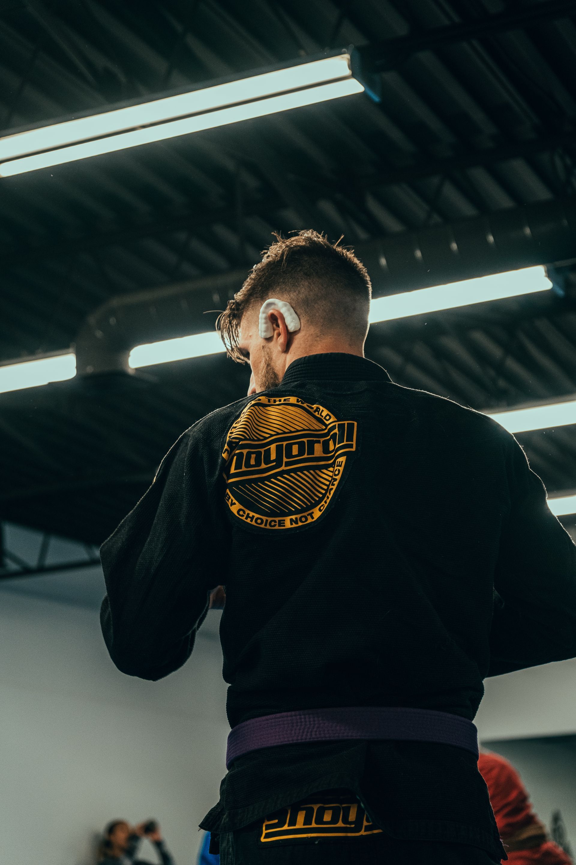 Person in a black outfit with gold logo patches, viewed from behind in the best martial arts center in Ottawa, ON