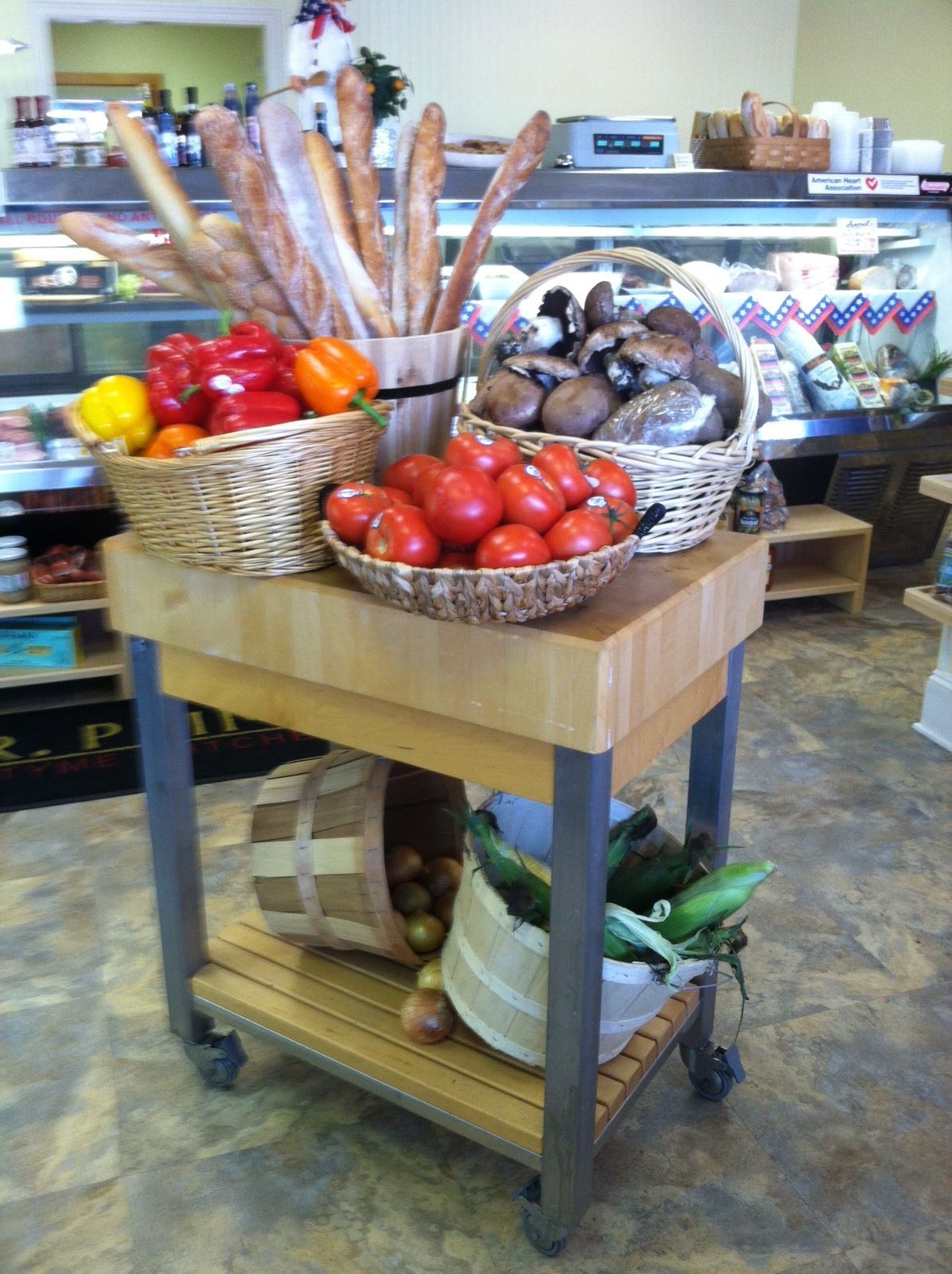 A wooden cart filled with baskets of fruits and vegetables
