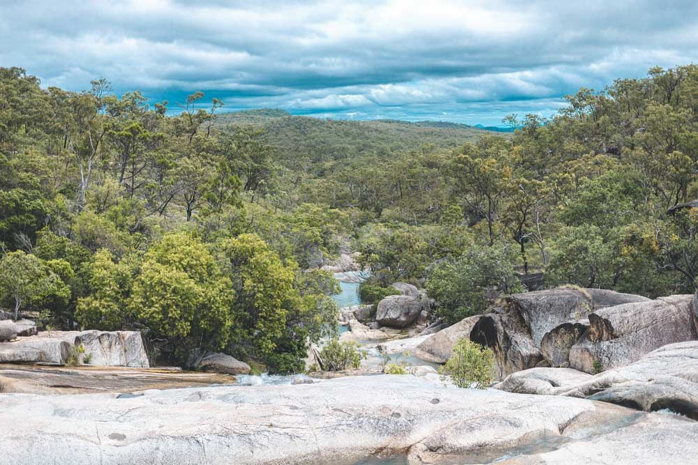 A River Runs Through a Lush Green Forest Surrounded by Rocks and Trees — Blue Gum Earthworks in Atherton, QLD