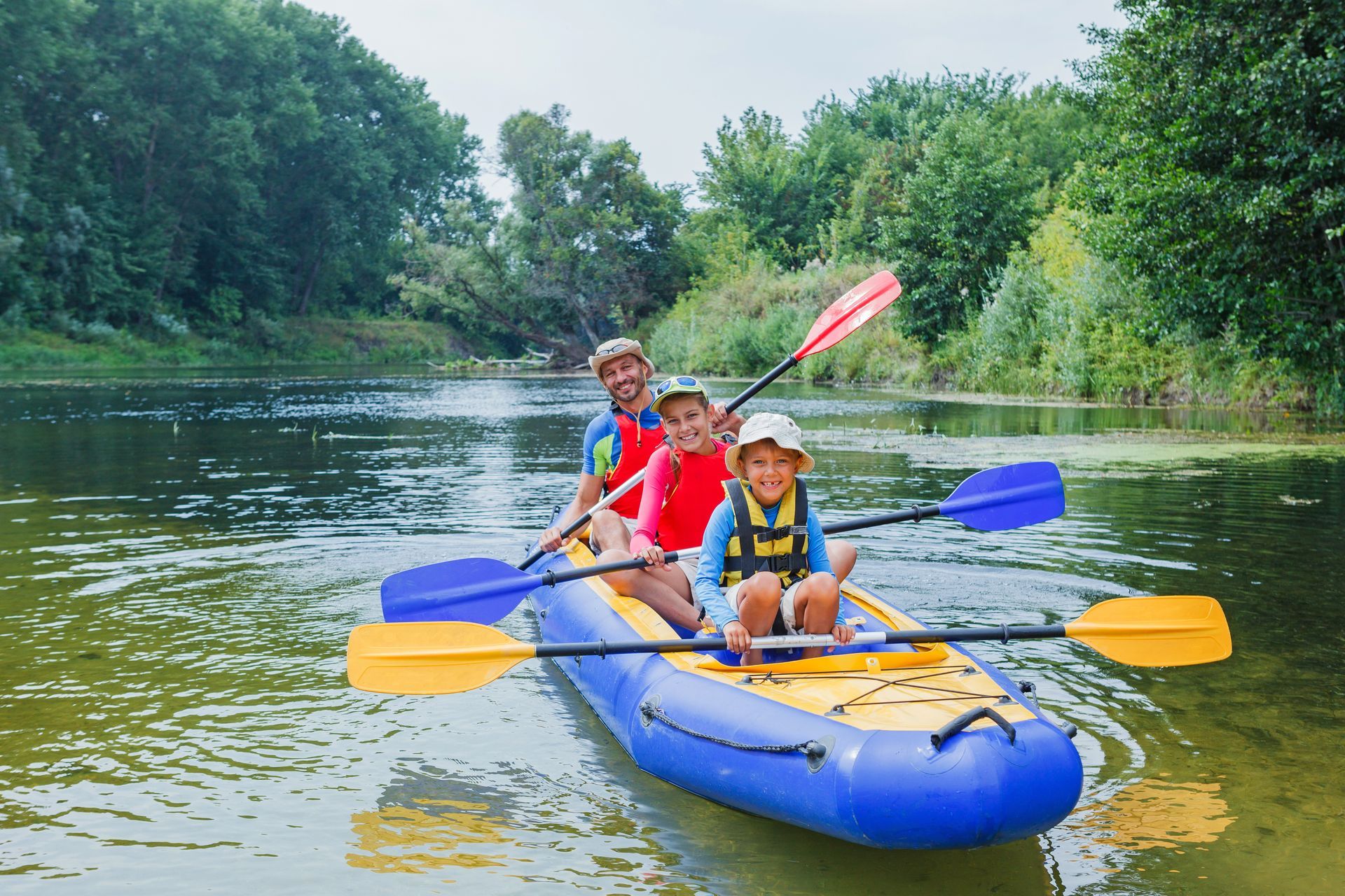 A family is paddling a kayak down a river.