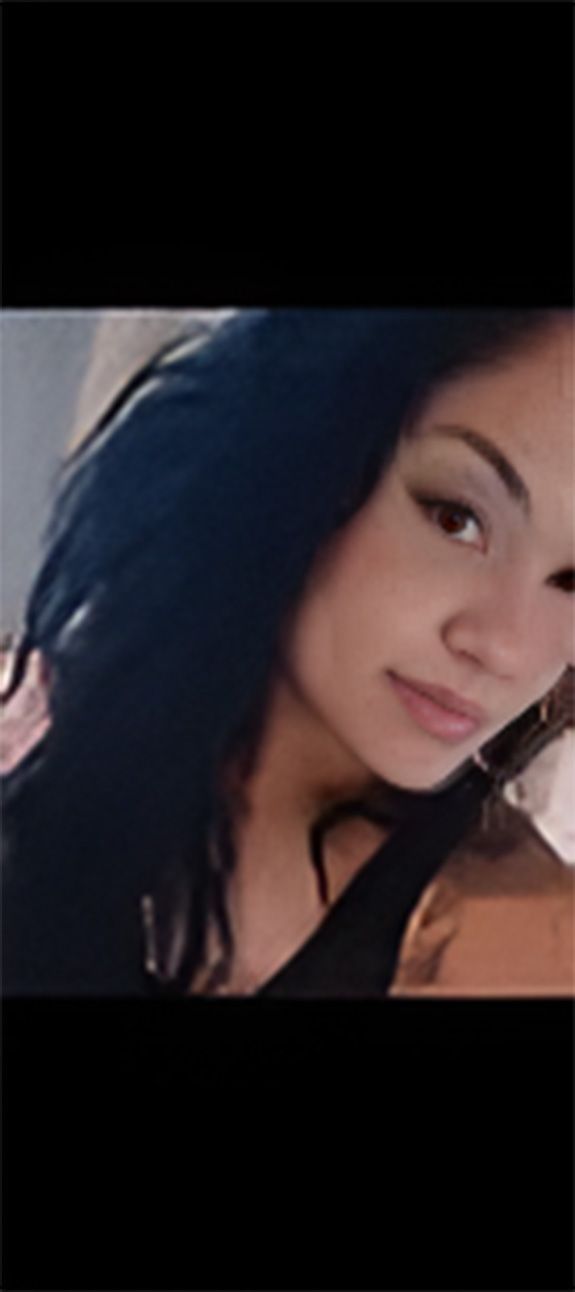 A close up of a woman 's face with long black hair.