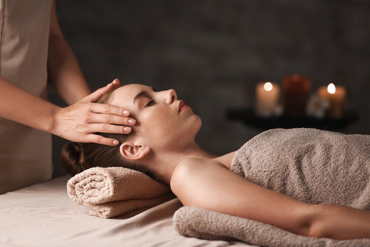 A woman is getting a head massage at a spa.