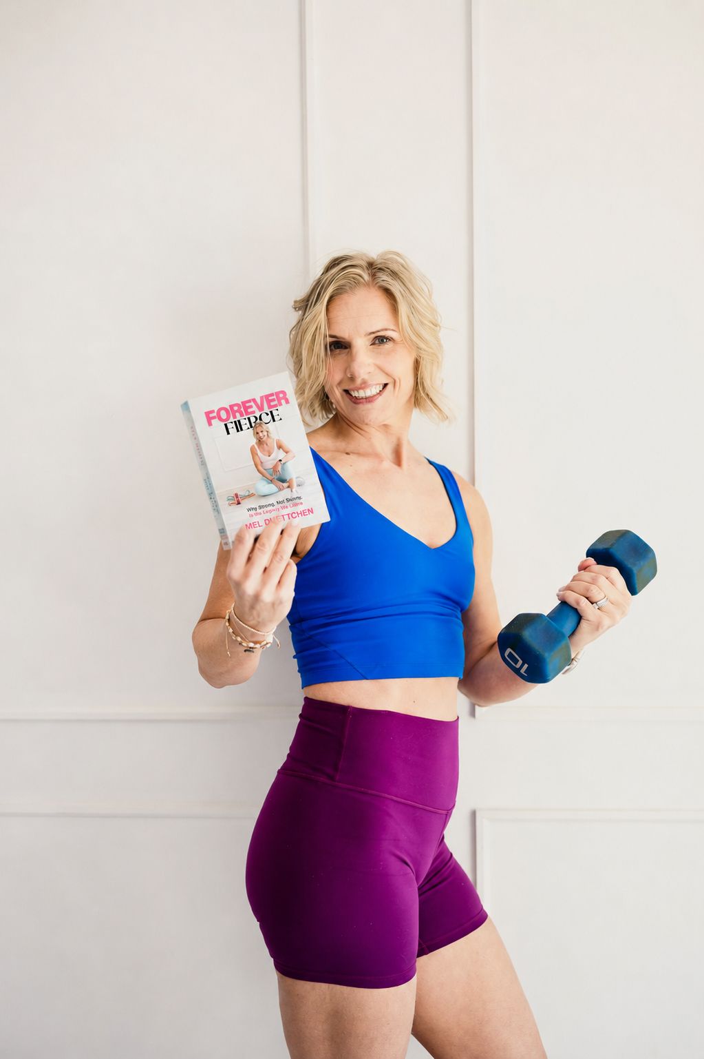 Mel Duettchen holding Forever Fierce and a dumbbell