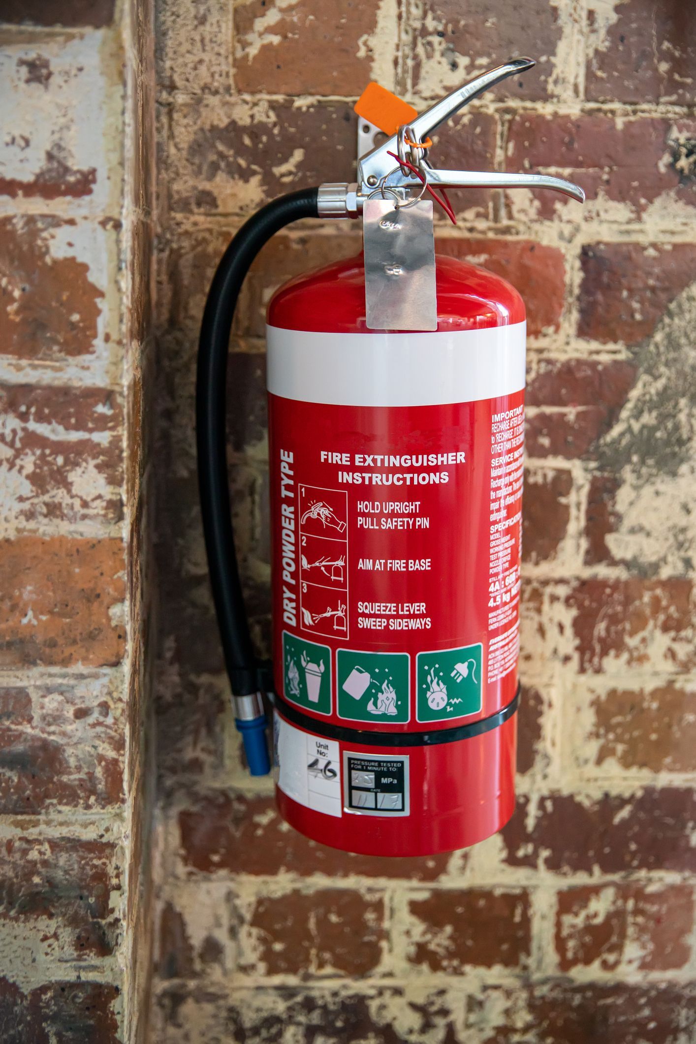A red fire extinguisher is hanging on a wall in a kitchen.