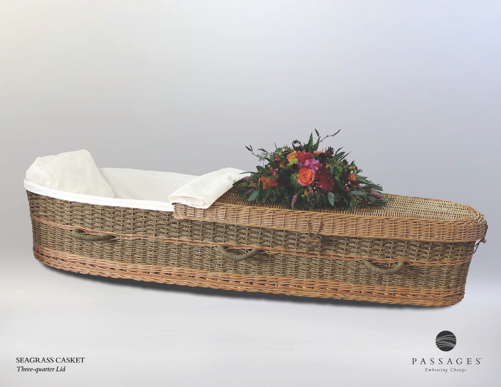 Wicker coffin with floral arrangement, white interior.