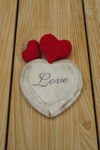 Two red hearts atop a white heart-shaped ornament with 