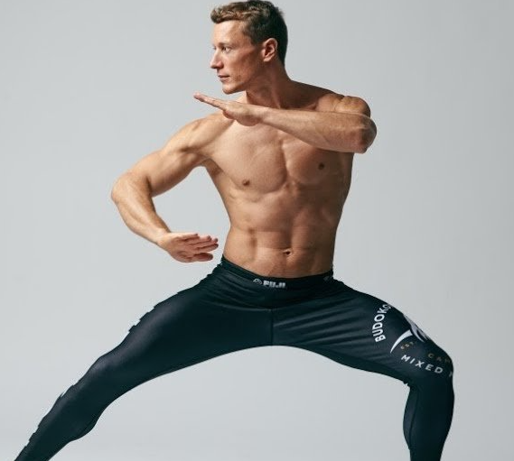 Guy in jiu jitsu spats doing a yoga pose