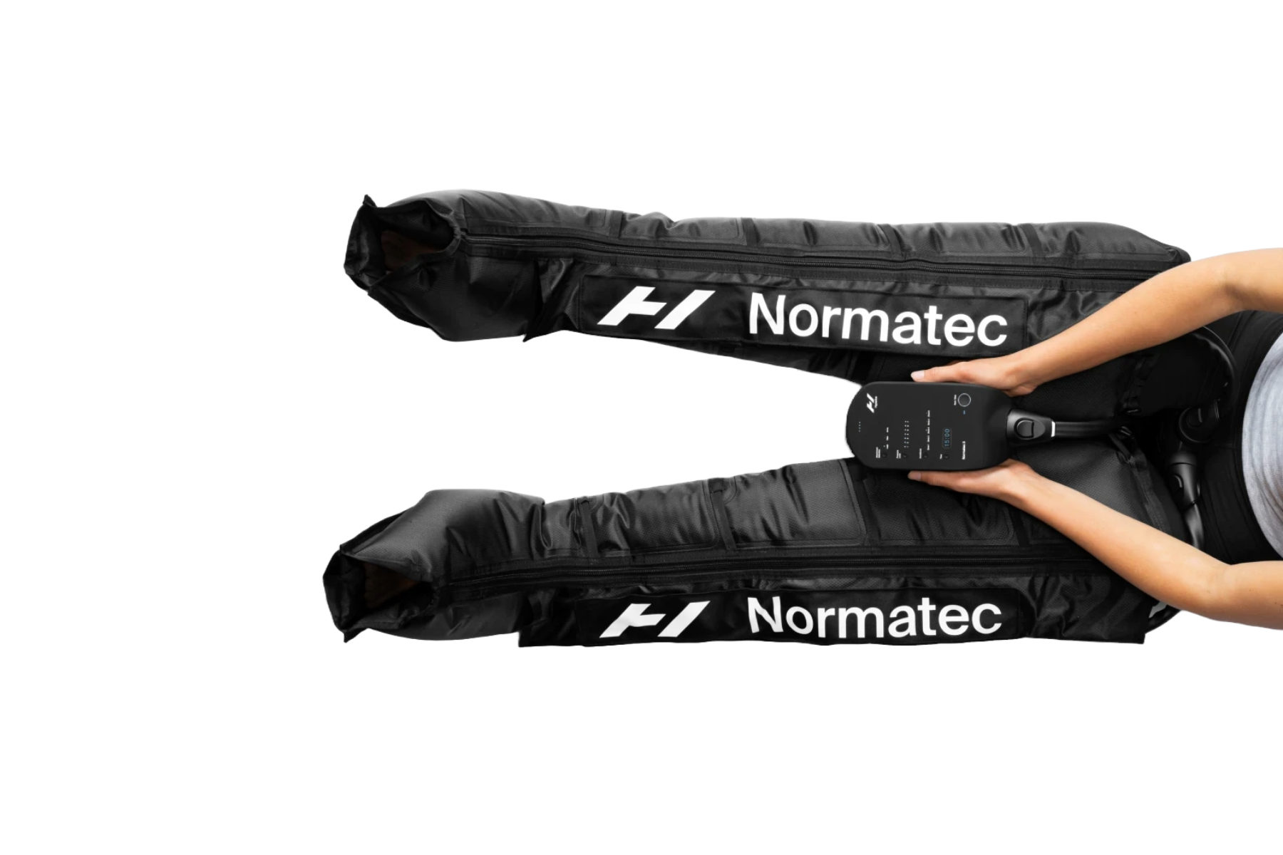 Person using black Normatec leg compression boots with control unit.