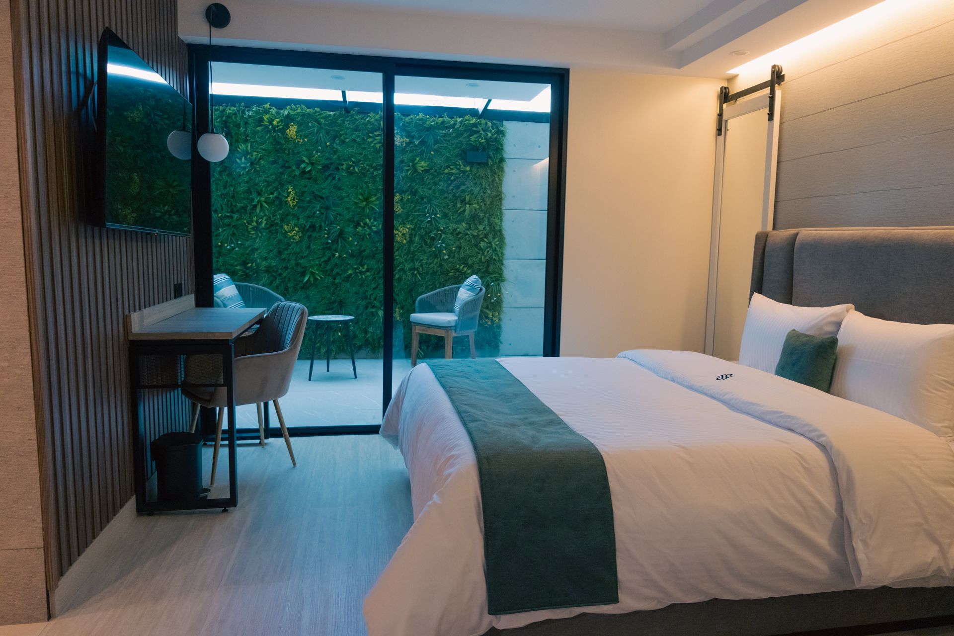 A hotel room with a bed , desk , chair and television.