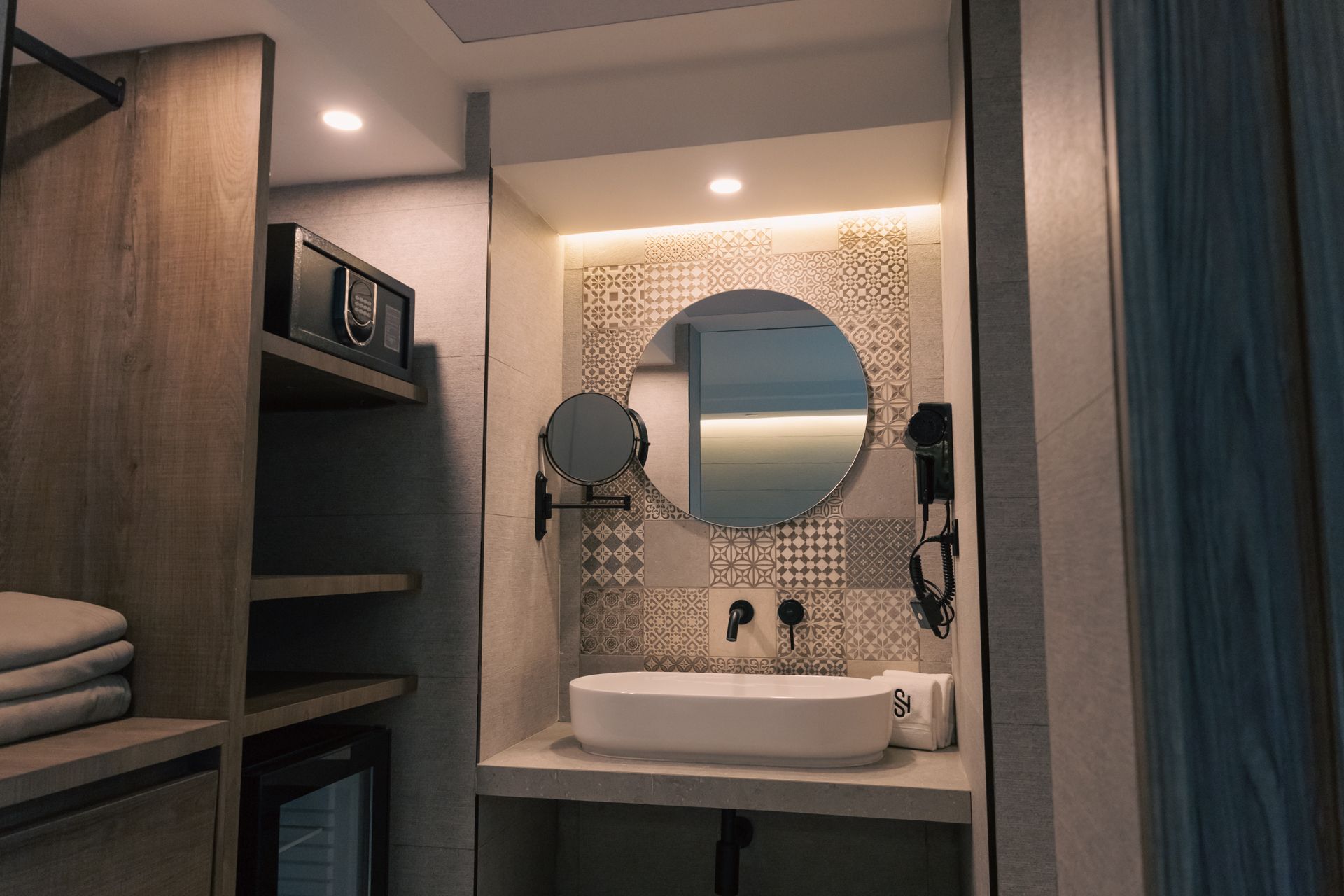 A bathroom with a sink , mirror and dryer.