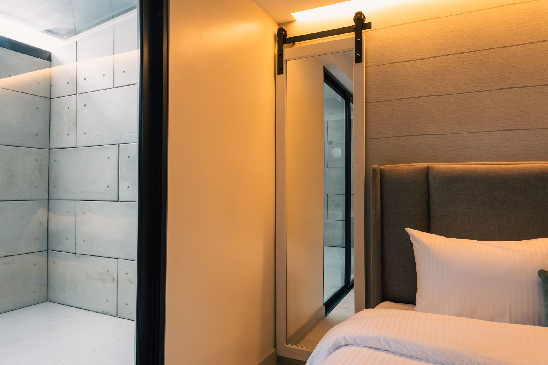 A bedroom with a bed and a mirror on the wall