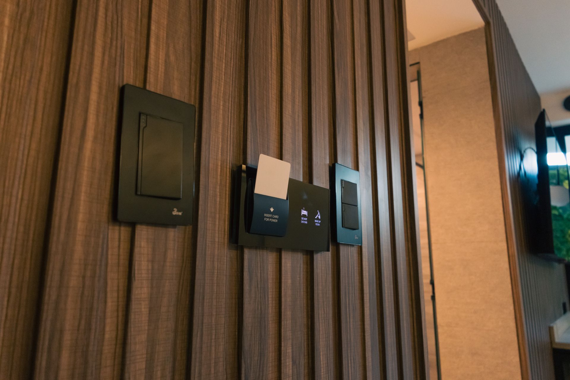 A close up of a light switch on a wooden wall.