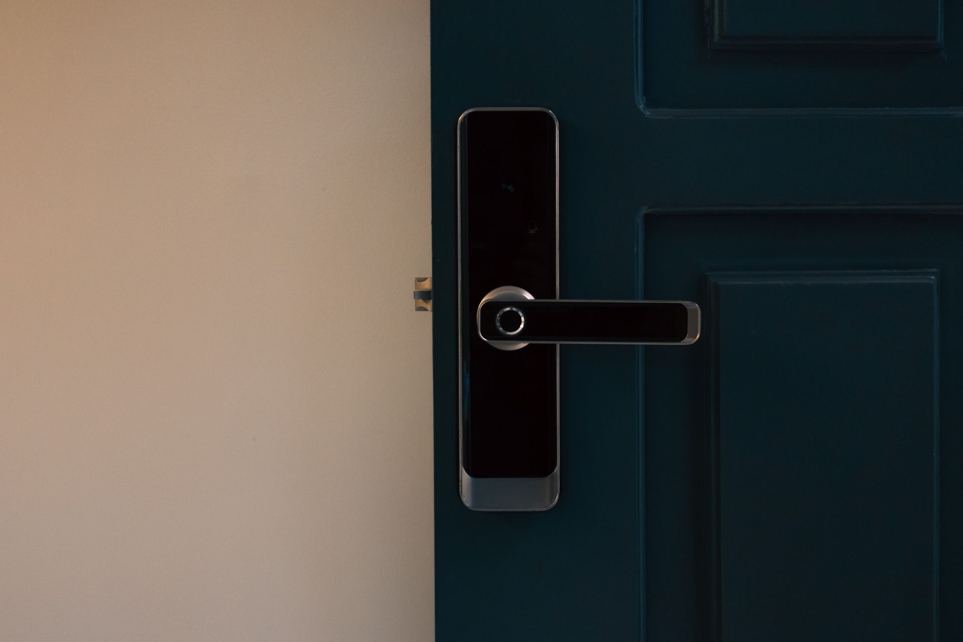 A close up of a smart door lock on a blue door.