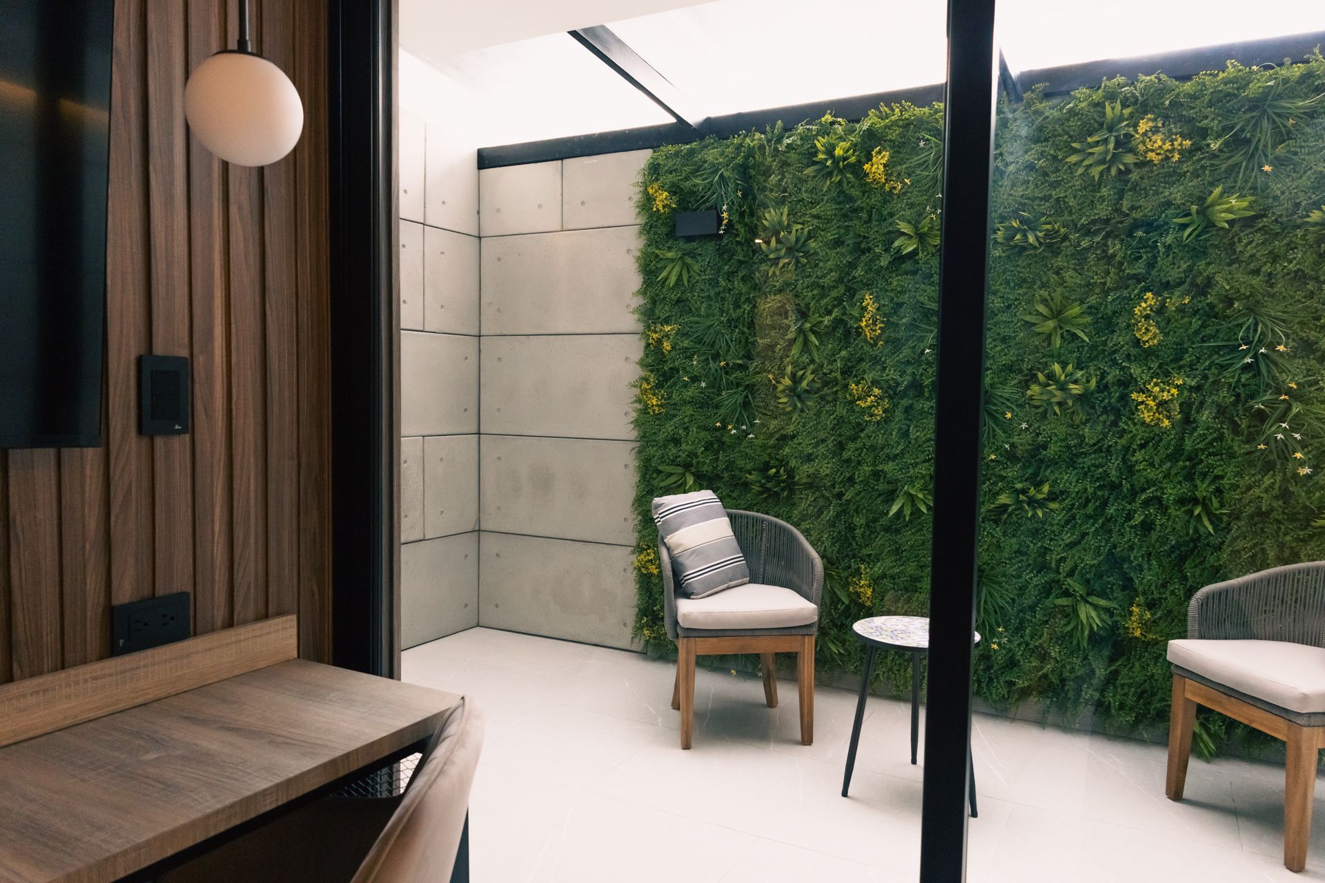 A room with a table , chairs and a green wall.
